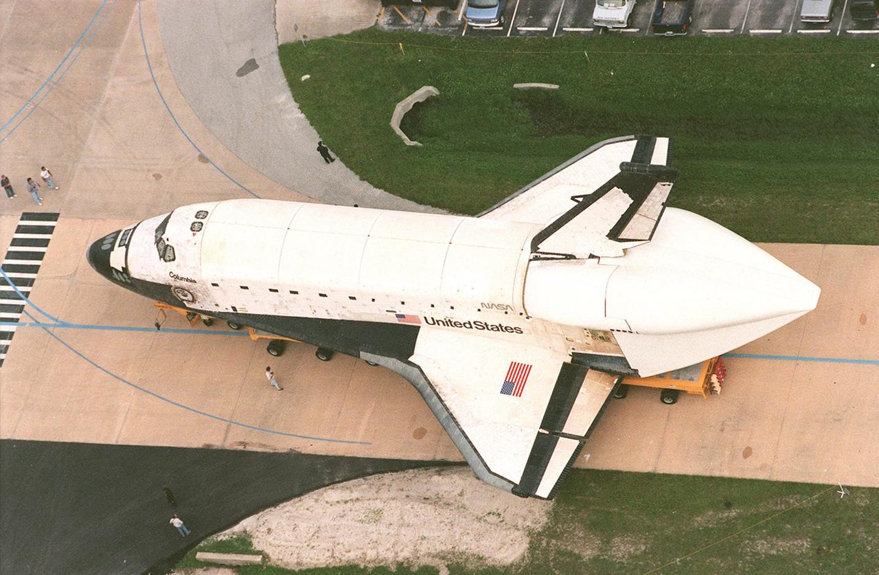 KENNEDY SPACE CENTER, FLA. -- On an orbiter transporter, Columbia is turned, after rolling out of KSC's Orbiter Processing Facility bay 3, for its move to the Shuttle Landing Facility's (SLF) Mate-Demate Device. At the SLF the orbiter is to be mated to the Boeing 747 Shuttle Carrier Aircraft for a ferry flight to Palmdale, Calif. On the rear of the orbiter can be seen the tail cone, a fairing that is installed over the aft fuselage of the orbiter to decrease aerodynamic drag and buffet when the Shuttle Carrier Aircraft is transporting the orbiter cross-country. It is 36 feet long, 25 feet wide, and 22 feet high. Columbia, the oldest of four orbiters in NASA's fleet, will undergo extensive inspections and modifications in Boeing's Orbiter Assembly Facility during a nine-month orbiter maintenance down period (OMDP), the second in its history. Orbiters are periodically removed from flight operations for an OMDP. Columbia's first was in 1994. Along with more than 100 modifications on the vehicle, Columbia will be the second orbiter to be outfitted with the multifunctional electronic display system, or "glass cockpit." Columbia is expected to return to KSC in July 2000