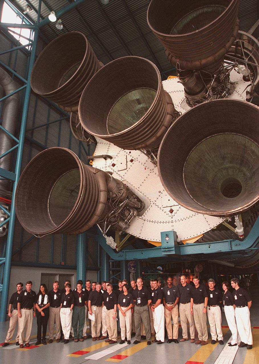 KENNEDY SPACE CENTER, FLA. -- At the Apollo/Saturn V Center, some of the 1998 astronaut candidate class (group 17) line up for a photo while standing under the engines of the Saturn V rocket on display. The U.S. candidates include Clayton C. Anderson, Lee J. Archambault, Tracy E. Caldwell (Ph.D.), Gregory E. Chamitoff (Ph.D.), Timothy J. Creamer, Christopher J. Ferguson, Michael J. Foreman, Michael E. Fossum, Kenneth T. Ham, Patricia C. Hilliard (M.D.), Gregory C. Johnson, Gregory H. Johnson, Stanley G. Love (Ph.D.), Leland D. Melvin, Barbara R. Morgan, William A. Oefelein, John D. Olivas (Ph.D.), Nicholas J.M. Patrick (Ph.D.), Alan G. Poindexter, Garrett E. Reisman (Ph.D.), Steven R. Swanson, Douglas H. Wheelock, Sunita L. Williams, Neil W. Woodward III, George D. Zamka; and international candidates Leopold Eyharts, Paolo Nespoli, Hans Schlegel, Roberto Vittori, Bjarni V. Tryggvason, and Marcos Pontes. The class is at KSC for training activities, including fire training and a flight awareness program, plus touring the OPF, SSME Processing Facility, VAB, SSPF, launch pads, SLF, Apollo/Saturn V Center and the crew headquarters