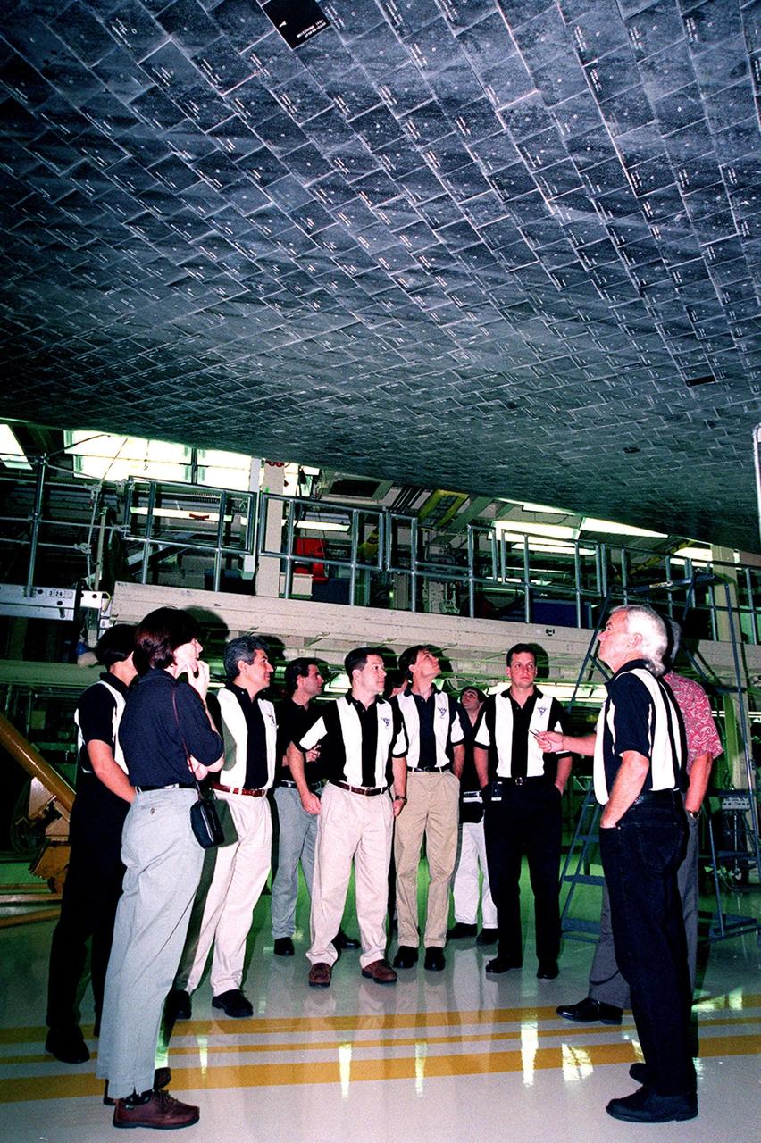 In the Orbiter Processing Facility bay 3, members of the 1998 astronaut candidate class (group 17) get a close-up view of the tiles, part of the thermal protection system, on the underside of the orbiter Atlantis overhead. The class is at KSC for training activities, including fire training and a flight awareness program, plus touring the OPF, SSME Processing Facility, VAB, SSPF, launch pads, SLF, Apollo/Saturn V Center and the crew headquarters. The U.S. candidates in the '98 class are Clayton C. Anderson, Lee J. Archambault, Tracy E. Caldwell (Ph.D.), Gregory E. Chamitoff (Ph.D.), Timothy J. Creamer, Christopher J. Ferguson, Michael J. Foreman, Michael E. Fossum, Kenneth T. Ham, Patricia C. Hilliard (M.D.), Gregory C. Johnson, Gregory H. Johnson, Stanley G. Love (Ph.D.), Leland D. Melvin, Barbara R. Morgan, William A. Oefelein, John D. Olivas (Ph.D.), Nicholas J.M. Patrick (Ph.D.), Alan G. Poindexter, Garrett E. Reisman (Ph.D.), Steven R. Swanson, Douglas H. Wheelock, Sunita L. Williams, Neil W. Woodward III, George D. Zamka; and the international candidates are Leopold Eyharts, Paolo Nespoli, Hans Schlegel, Roberto Vittori, Bjarni V. Tryggvason, and Marcos Pontes