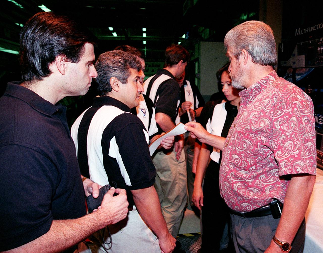 In the Orbiter Processing Facility bay 3, Larry Osheim (right), who is with United Space Alliance, shows members of the 1998 astronaut candidate class (group 17) a sample of Felt Reusable Surface Insulation (FRSI) blankets used on the orbiters. The class is at KSC for training activities, including fire training and a flight awareness program, plus touring the OPF, SSME Processing Facility, VAB, SSPF, launch pads, SLF, Apollo/Saturn V Center and the crew headquarters. The U.S. candidates in the '98 class are Clayton C. Anderson, Lee J. Archambault, Tracy E. Caldwell (Ph.D.), Gregory E. Chamitoff (Ph.D.), Timothy J. Creamer, Christopher J. Ferguson, Michael J. Foreman, Michael E. Fossum, Kenneth T. Ham, Patricia C. Hilliard (M.D.), Gregory C. Johnson, Gregory H. Johnson, Stanley G. Love (Ph.D.), Leland D. Melvin, Barbara R. Morgan, William A. Oefelein, John D. Olivas (Ph.D.), Nicholas J.M. Patrick (Ph.D.), Alan G. Poindexter, Garrett E. Reisman (Ph.D.), Steven R. Swanson, Douglas H. Wheelock, Sunita L. Williams, Neil W. Woodward III, George D. Zamka; and the international candidates are Leopold Eyharts, Paolo Nespoli, Hans Schlegel, Roberto Vittori, Bjarni V. Tryggvason, and Marcos Pontes