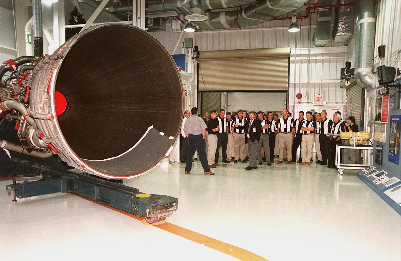 The 1998 astronaut candidate class (group 17) gather in the Space Shuttle Main Engine Processing (SSMEP) Facility. In the foreground is one of the main shuttle engines. The class is at KSC for training activities, including fire training and a flight awareness program, plus touring the OPF, SSME Processing Facility, VAB, SSPF, launch pads, SLF, Apollo/Saturn V Center and the crew headquarters. The U.S. candidates in the '98 class are Clayton C. Anderson, Lee J. Archambault, Tracy E. Caldwell (Ph.D.), Gregory E. Chamitoff (Ph.D.), Timothy J. Creamer, Christopher J. Ferguson, Michael J. Foreman, Michael E. Fossum, Kenneth T. Ham, Patricia C. Hilliard (M.D.), Gregory C. Johnson, Gregory H. Johnson, Stanley G. Love (Ph.D.), Leland D. Melvin, Barbara R. Morgan, William A. Oefelein, John D. Olivas (Ph.D.), Nicholas J.M. Patrick (Ph.D.), Alan G. Poindexter, Garrett E. Reisman (Ph.D.), Steven R. Swanson, Douglas H. Wheelock, Sunita L. Williams, Neil W. Woodward III, George D. Zamka; and the international candidates are Leopold Eyharts, Paolo Nespoli, Hans Schlegel, Roberto Vittori, Bjarni V. Tryggvason, and Marcos Pontes