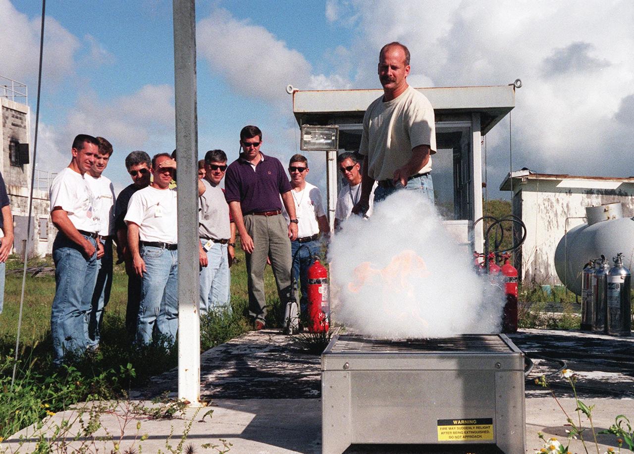 KENNEDY SPACE CENTER, FLA. -- On the grounds of the Kennedy Space Center, members of the 1998 astronaut candidate class (Group 17) watch as candidate Alan G. Poindexter practices using firefighting equipment during fire training. The class is at KSC for training activities, including a flight awareness program, plus touring the OPF, VAB, SSPF, SSME Processing Facility, launch pads, SLF, Apollo/Saturn V Center, and the crew quarters. The other U.S. candidates in the '98 class are Clayton C. Anderson, Lee J. Archambault, Tracy E. Caldwell (Ph.D.), Gregory E. Chamitoff (Ph.D.), Timothy J. Creamer, Christopher J. Ferguson, Michael J. Foreman, Michael E. Fossum, Kenneth T. Ham, Patricia C. Hilliard (M.D.), Gregory C. Johnson, Gregory H. Johnson, Stanley G. Love (Ph.D.), Leland D. Melvin, Barbara R. Morgan, William A. Oefelein, John D. Olivas (Ph.D.), Nicholas J.M. Patrick (Ph.D.), Garrett E. Reisman (Ph.D.), Steven R. Swanson, Douglas H. Wheelock, Sunita L. Williams, Neil W. Woodward III, George D. Zamka; and the international candidates are Leopold Eyharts, Paolo Nespoli, Hans Schlegel, Roberto Vittori, Bjarni V. Tryggvason, and Marcos Pontes