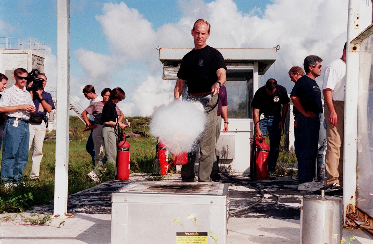 KENNEDY SPACE CENTER, FLA. -- On the grounds of the Kennedy Space Center, members of the 1998 astronaut candidate class (Group 17) watch as candidate Clayton C. Anderson practices using firefighting equipment during fire training. The class is at KSC for training activities, including a flight awareness program, plus touring the OPF, VAB, SSPF, SSME Processing Facility, launch pads, SLF, Apollo/Saturn V Center, and the crew quarters. The other U.S. candidates in the '98 class are Lee J. Archambault, Tracy E. Caldwell (Ph.D.), Gregory E. Chamitoff (Ph.D.), Timothy J. Creamer, Christopher J. Ferguson, Michael J. Foreman, Michael E. Fossum, Kenneth T. Ham, Patricia C. Hilliard (M.D.), Gregory C. Johnson, Gregory H. Johnson, Stanley G. Love (Ph.D.), Leland D. Melvin, Barbara R. Morgan, William A. Oefelein, John D. Olivas (Ph.D.), Nicholas J.M. Patrick (Ph.D.), Alan G. Poindexter, Garrett E. Reisman (Ph.D.), Steven R. Swanson, Douglas H. Wheelock, Sunita L. Williams, Neil W. Woodward III, George D. Zamka; and the international candidates are Leopold Eyharts, Paolo Nespoli, Hans Schlegel, Roberto Vittori, Bjarni V. Tryggvason, and Marcos Pontes