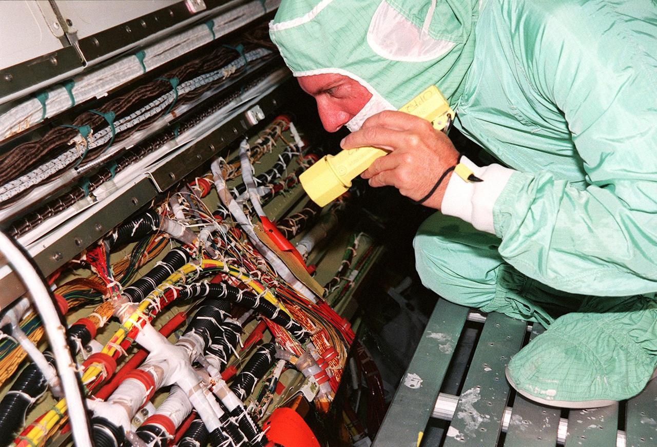 A short during liftoff of Space Shuttle Columbia in July was traced to a wire in the payload bay with damaged insulation. As a result of that problem, NASA decided to inspect much of the wiring in all four Space Shuttles and make repairs as required. Here a technician is examining the wires onboard orbiter Endeavour. The next Shuttle mission, STS-103, the Third Hubble Space Telescope Servicing Mission, is currently scheduled for launch no earlier than Nov. 19, 1999