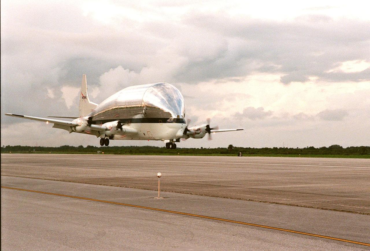 KENNEDY SPACE CENTER, FLA. -- NASA's Super Guppy airplane, with the International Space Station's (ISS) S1 truss aboard, arrives at KSC's Shuttle Landing Facility from Marshall Space Flight Center. Manufactured by the Boeing Co. in Huntington Beach, Calif., this component of the ISS is the first starboard (right-side) truss segment, whose main job is providing structural support for the orbiting research facility's radiator panels that cool the Space Station's complex power system. The S1 truss segment also will house communications systems, external experiment positions and other subsystems. Primarily constructed of aluminum, the truss segment is 45 feet long, 15 feet wide and 6 feet tall. When fully outfitted, it will weigh 31,137 pounds. The truss is slated for flight in 2001. The Super Guppy, with its 25-foot diameter fuselage designed to handle oversized loads, is well prepared to transport the truss and other ISS segments. Loading the Guppy is easy because of the unique "fold-away" nose of the aircraft that opens 110 degrees for cargo loading. A system of rails in the cargo compartment, used with either Guppy pallets or fixtures designed for specific cargo, makes cargo loading simple and efficient. Rollers mounted in the rails allow pallets or fixtures to be moved by an electric winch mounted beneath the cargo floor. Automatic hydraulic lock pins in each rail secure the pallet for flight. The truss is to be moved to the Operations and Checkout Building