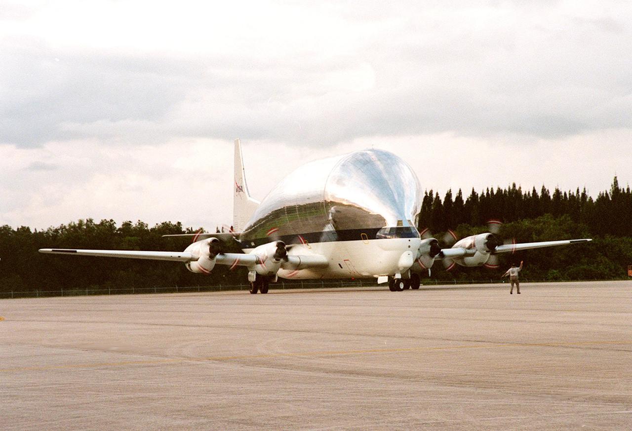 KENNEDY SPACE CENTER, FLA. -- NASA's Super Guppy airplane, with the International Space Station's (ISS) S1 truss aboard, rolls to a stop at KSC's Shuttle Landing Facility. Manufactured by the Boeing Co. in Huntington Beach, Calif., this component of the ISS is the first starboard (right-side) truss segment, whose main job is providing structural support for the orbiting research facility's radiator panels that cool the Space Station's complex power system. The S1 truss segment also will house communications systems, external experiment positions and other subsystems. Primarily constructed of aluminum, the truss segment is 45 feet long, 15 feet wide and 6 feet tall. When fully outfitted, it will weigh 31,137 pounds. The truss is slated for flight in 2001. The Super Guppy, with its 25-foot diameter fuselage designed to handle oversized loads, is well prepared to transport the truss and other ISS segments. Loading the Guppy is easy because of the unique "fold-away" nose of the aircraft that opens 110 degrees for cargo loading. A system of rails in the cargo compartment, used with either Guppy pallets or fixtures designed for specific cargo, makes cargo loading simple and efficient. Rollers mounted in the rails allow pallets or fixtures to be moved by an electric winch mounted beneath the cargo floor. Automatic hydraulic lock pins in each rail secure the pallet for flight. The truss is to be transferred to the Operations and Checkout Building