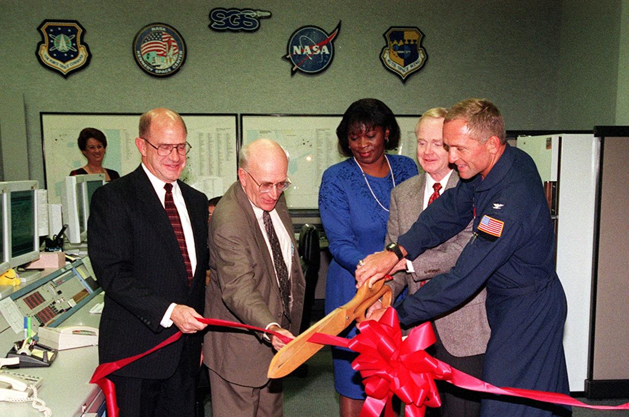 Cutting the ribbon at a ceremony for the opening of the Consolidated Support Operations Center at ROCC, Cape Canaveral Air Station, are (left to right) William P. Hickman, program manager, Space Gateway Support; Ed Gormel, executive director, JPMO; Barbara White, supervisor, Mission Support; KSC Center Director Roy Bridges, and Lt Col Steve Vuresky, USAF