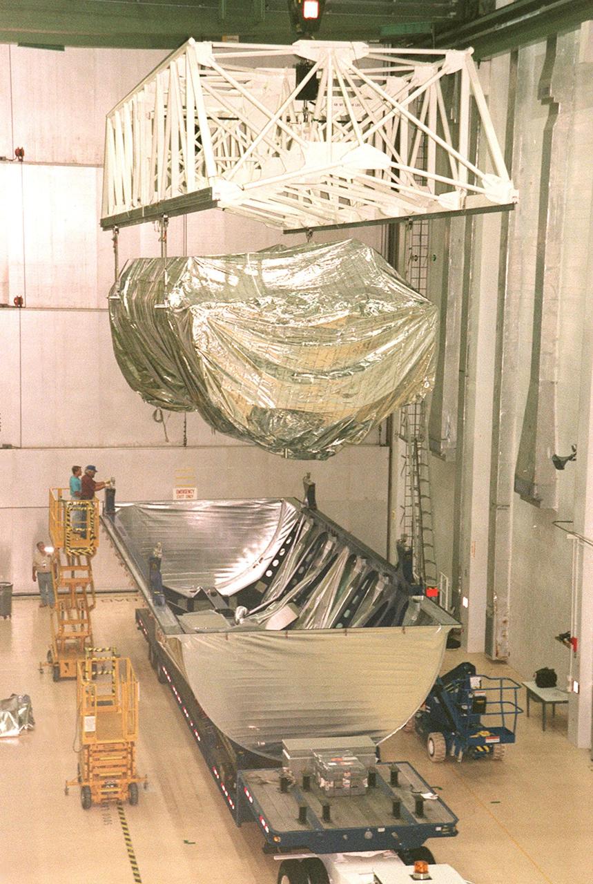 KENNEDY SPACE CENTER, FLA. -- Inside the Operations and Checkout Building, a strongback lifts the S1 truss from the Guppy cargo carrier that protected it during flight and transfer. Manufactured by the Boeing Co. in Huntington Beach, Calif., this component of the International Space Station is the first starboard (right-side) truss segment, whose main job is providing structural support for the orbiting research facility's radiator panels that cool the Space Station's complex power system. The S1 truss segment also will house communications systems, external experiment positions and other subsystems. Primarily constructed of aluminum, the truss segment is 45 feet long, 15 feet wide and 6 feet tall. When fully outfitted, it will weigh 31,137 pounds. The truss is slated for flight in 2001