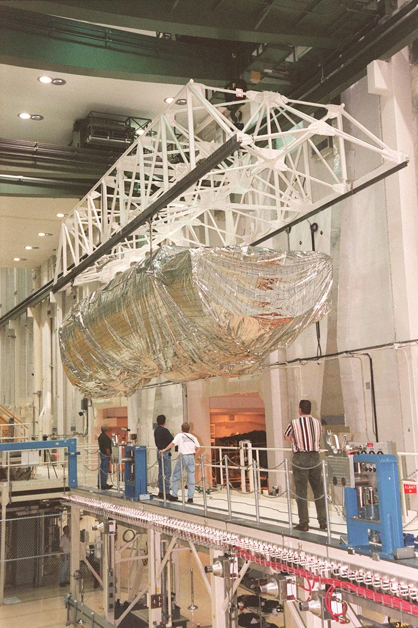KENNEDY SPACE CENTER, FLA. -- Inside the Operations and Checkout Building, the S1 truss, a segment of the International Space Station, is moved toward workstand number three. Manufactured by the Boeing Co. in Huntington Beach, Calif., this component of the International Space Station is the first starboard (right-side) truss segment, whose main job is providing structural support for the orbiting research facility's radiator panels that cool the Space Station's complex power system. The S1 truss segment also will house communications systems, external experiment positions and other subsystems. Primarily constructed of aluminum, the truss segment is 45 feet long, 15 feet wide and 6 feet tall. When fully outfitted, it will weigh 31,137 pounds. The truss is slated for flight in 2001