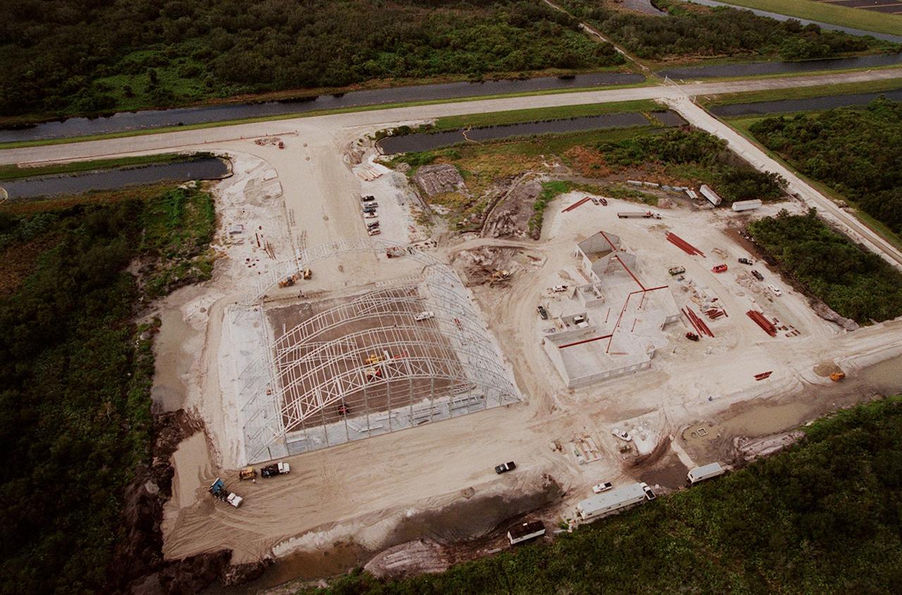 Construction continues on an $8 million Reusable Launch Vehicle (RLV) Support Complex at Kennedy Space Center. At left is a multi-purpose hangar and at right a building for related ground support equipment and administrative/ technical support. The complex is situated at the Shuttle Landing Facility (upper right). Near the top of the photo is the tow-way. The RLV complex will be available to accommodate the Space Shuttle; the X-34 RLV technology demonstrator; the L-1011 carrier aircraft for Pegasus and X-34; and other RLV and X-vehicle programs. The complex is jointly funded by the Spaceport Florida Authority, NASA's Space Shuttle Program and KSC. The facility will be operational in early 2000