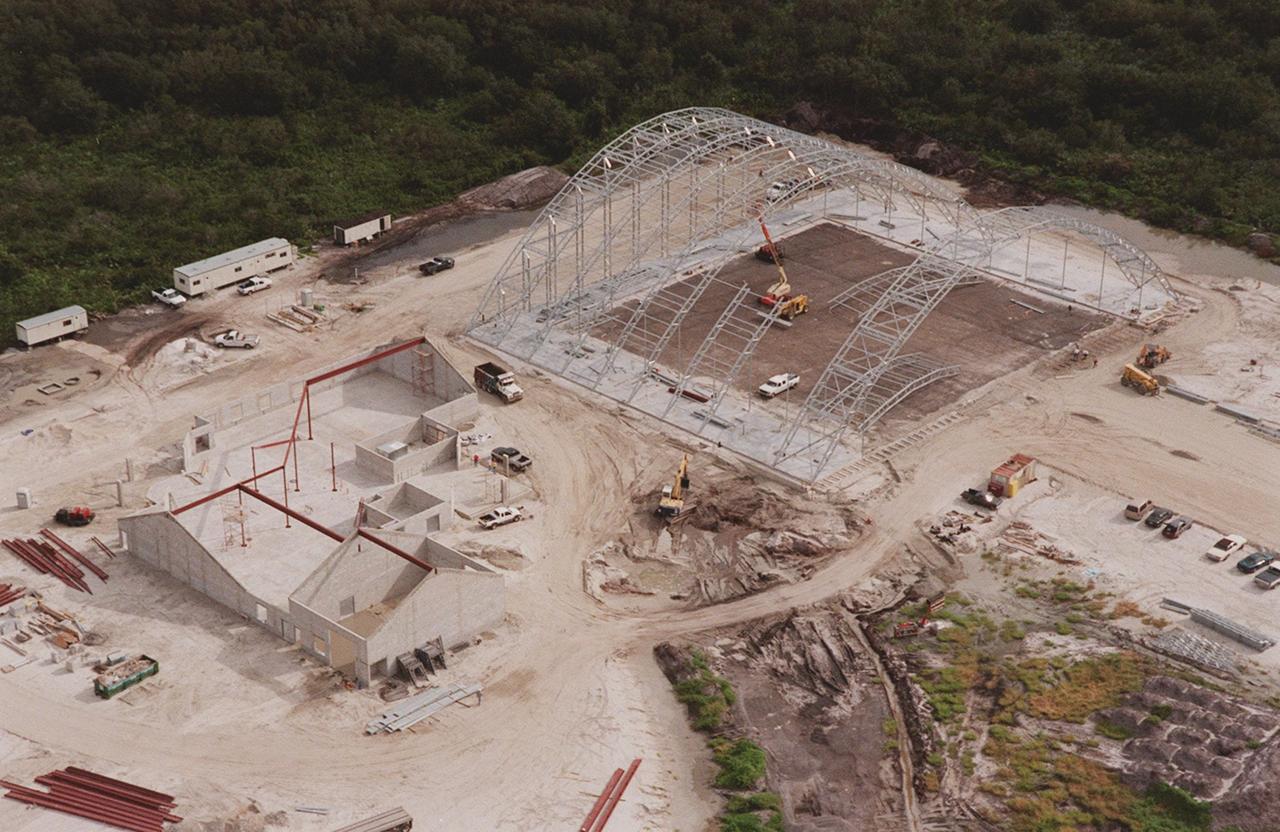 An aerial closeup view reveals the ongoing construction of an $8 million Reusable Launch Vehicle (RLV) Support Complex at Kennedy Space Center. At right is a multi-purpose hangar and at left a building for related ground support equipment and administrative/ technical support. The complex is situated at the Shuttle Landing Facility. Near the top of the photo can be seen the tow-way. The RLV complex will be available to accommodate the Space Shuttle; the X-34 RLV technology demonstrator; the L-1011 carrier aircraft for Pegasus and X-34; and other RLV and X-vehicle programs. The complex is jointly funded by the Spaceport Florida Authority, NASA's Space Shuttle Program and KSC. The facility will be operational in early 2000