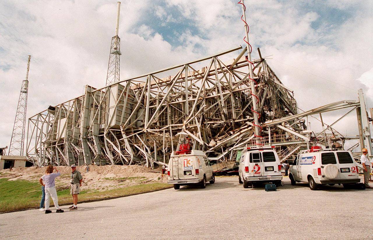 KENNEDY SPACE CENTER, FLA. -- Live TV trucks from local channels merge at the site of the fallen Mobile Service Tower (MST) and umbilical tower nearby after their demolition. The towers were demolished to make room for Lockheed Martin's 14-acre Vehicle Integration Facility (VIF), under construction. Weighing two million pounds, the umbilical tower was approximately 200 feet high. The taller 300-foot MST weighed five million pounds. About 200 pounds of linear-shaped charges were used to bring down the towers so that the materials can be recycled. The implosion and removal of the tower debris is expected to be completed in two months. The VIF will be used for Lockheed Martin's Atlas V Launch System.