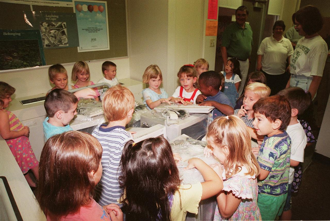Children at Coquina Elementary School, Titusville, Fla., look with curiosity at the wrapped computer equipment donated by Kennedy Space Center. Coquina is one of 13 Brevard County schools receiving 81 excess contractor computers thanks to an innovative educational outreach project spearheaded by the Nasa k-12 Education Services Office at ksc. The Astronaut Memorial Foundation, a strategic partner in the effort, and several schools in rural Florida and Georgia also received refurbished computers as part of the year-long project. KSC employees put in about 3,300 volunteer hours to transform old, excess computers into upgraded, usable units. A total of $90,000 in upgraded computer equipment is being donated