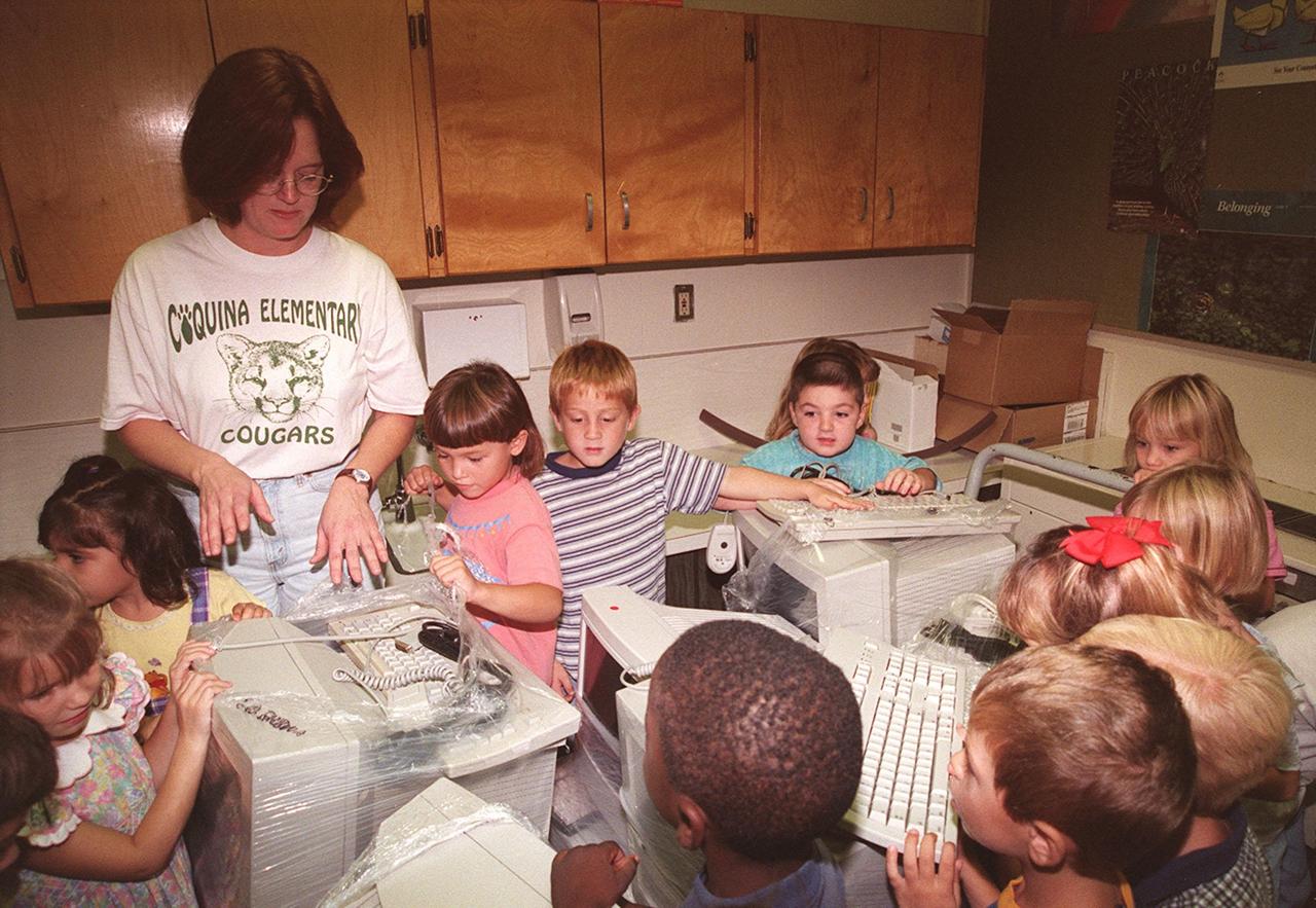 Children at Coquina Elementary School, Titusville, Fla., excitedly tear into the wrapped computer equipment donated by Kennedy Space Center. Coquina is one of 13 Brevard County schools receiving 81 excess contractor computers thanks to an innovative educational outreach project spearheaded by the Nasa k-12 Education Services Office at ksc. The Astronaut Memorial Foundation, a strategic partner in the effort, and several schools in rural Florida and Georgia also received refurbished computers as part of the year-long project. KSC employees put in about 3,300 volunteer hours to transform old, excess computers into upgraded, usable units. A total of $90,000 in upgraded computer equipment is being donated