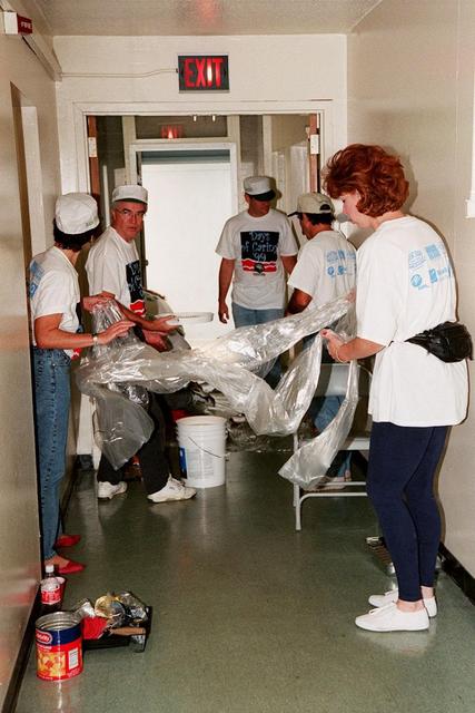 KSC volunteers for Days of Caring '99 unfold protective materials before getting ready to paint at Baxley Manor, an apartment building for senior citizens on Merritt Island. Coordinated by the KSC Community Relations Council, Days of Caring provides an opportunity for employees to volunteer their services in projects such as painting, planting flowers, reading to school children, and more. Organizations accepting volunteers include The Embers, Yellow Umbrella, Serene Harbor, Domestic Violence Program, the YMCA of Brevard County, and others