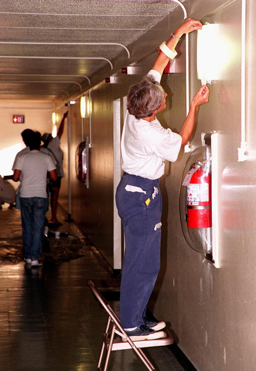 A volunteer for Days of Caring '99 prepares a light fixture before painting the walls in the hallway at Baxley Manor, an apartment building for senior citizens on Merritt Island. Coordinated by the KSC Community Relations Council, Days of Caring provides an opportunity for employees to volunteer their services in projects such as painting, planting flowers, reading to school children, and more. Organizations accepting volunteers include The Embers, Yellow Umbrella, Serene Harbor, Domestic Violence Program, the YMCA of Brevard County, and others