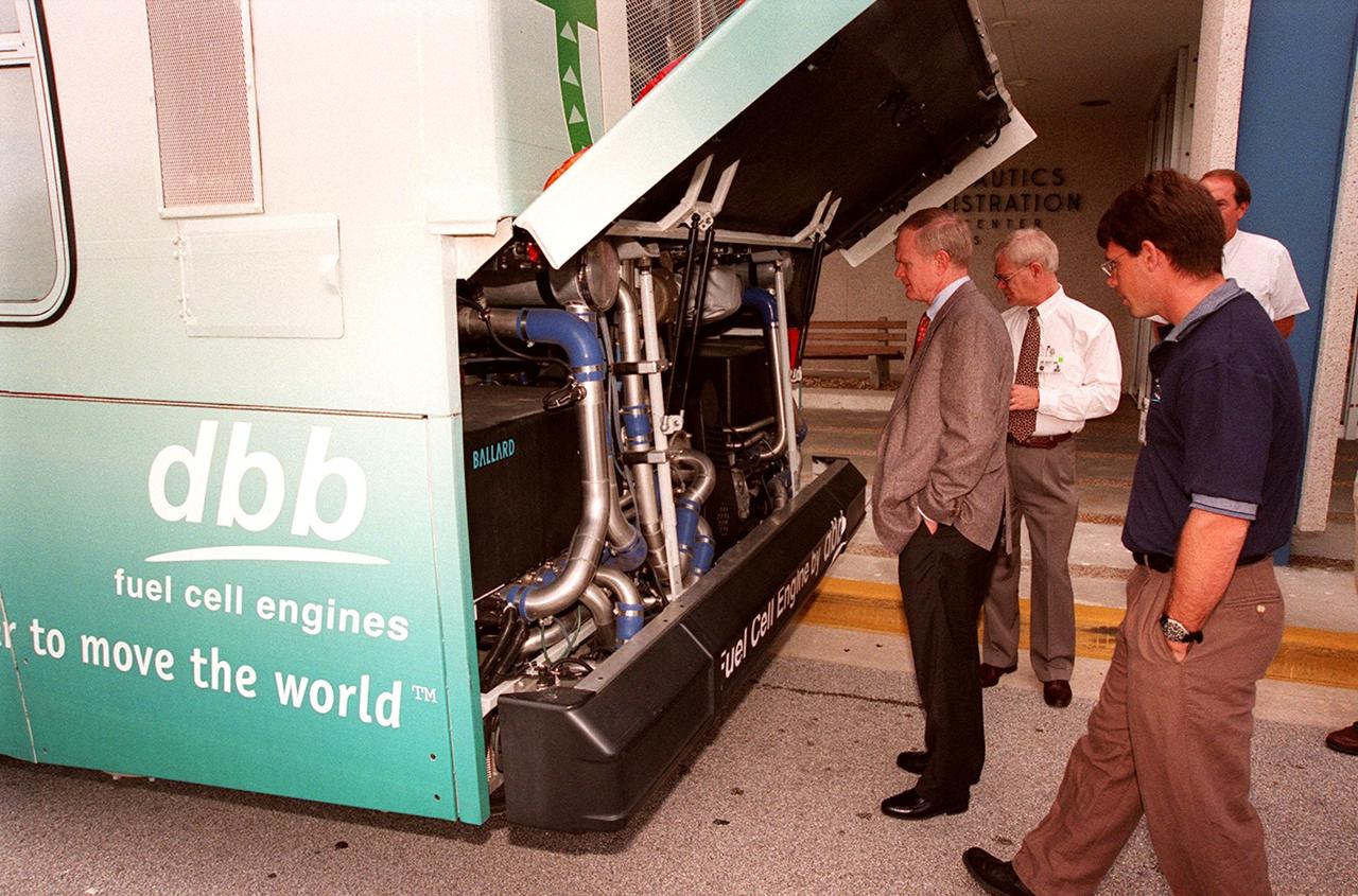 In front of the Headquarters Building at KSC, Center Director Roy Bridges (left) looks at the hydrogen-oxygen driven engine powering a Zero Emissions (ZE) transit bus. Provided by dbb fuel cell engines inc. of Vancouver, Canada, the ZE bus was brought to KSC as part of the Center's Alternative Fuel Initiatives Program. The bus uses a Proton Exchange Membrane fuel cell in which hydrogen and oxygen, from atmospheric air, react to produce electricity that powers an electric motor drive system. The by-product "exhaust" from the fuel cell is water vapor, thus zero harmful emissions. A typical diesel-powered bus emits more than a ton of harmful pollutants from its exhaust every year. Available for viewing by employees, the ZE bus is also being used on tour routes at the KSC Visitor Complex Oct. 26-27