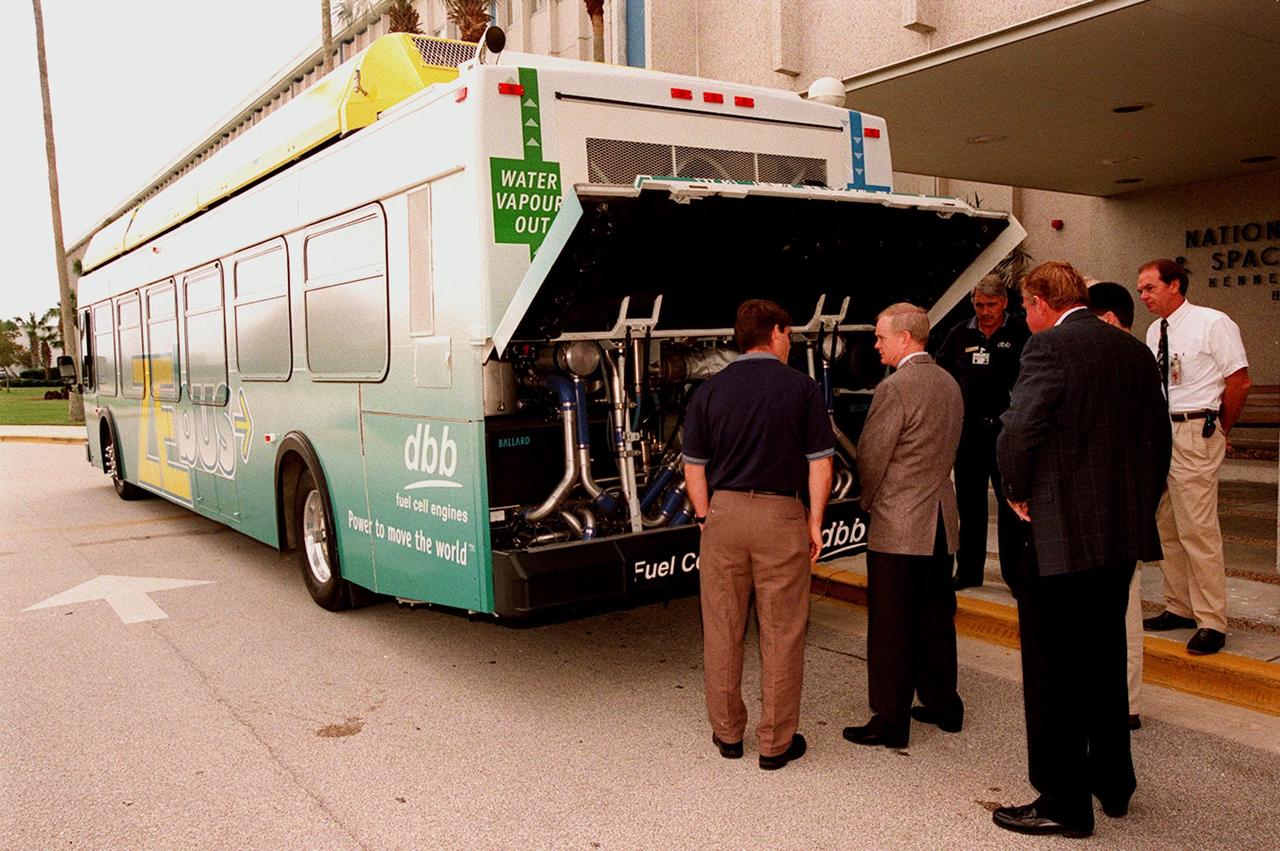 KSC employees, along with Center Director Roy Bridges (second from left), view the hydrogen-oxygen driven engine powering a Zero Emissions (ZE) transit bus. Provided by dbb fuel cell engines inc. of Vancouver, Canada, the ZE bus was brought to KSC as part of the Center's Alternative Fuel Initiatives Program. The bus uses a Proton Exchange Membrane fuel cell in which hydrogen and oxygen, from atmospheric air, react to produce electricity that powers an electric motor drive system. The by-product "exhaust" from the fuel cell is water vapor, thus zero harmful emissions. A typical diesel-powered bus emits more than a ton of harmful pollutants from its exhaust every year. Available for viewing by employees, the ZE bus is also being used on tour routes at the KSC Visitor Complex Oct. 26-27