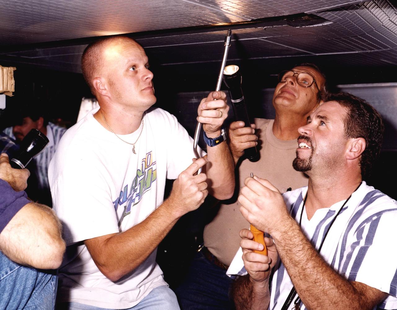 KSC technician David Rowell works on the wing of the modified X-34, known as A-1A, at the Dryden Flight Research Center, Calif. Looking on are Art Cape, with Dryden, and Mike Brainard, with Orbital Sciences Corporation. Rowell is one of eight NASA engineering technicians from KSC's Engineering Prototype Lab who have assisted Orbital and Dryden in the complex process of converting the X-34 A-1 vehicle from captive carry status to unpowered flight status, the A-1A. The other KSC technicians are Kevin Boughner, Roger Cartier, Mike Dininny, Mike Lane, Jerry Moscoso, James Niehoff Jr. and Bryan Taylor. The X-34 is 58.3 feet long, 27.7 feet wide from wing tip to wing tip, and 11.5 feet tall from the bottom of the fuselage to the top of the tail. The autonomously operated technology demonstrator will be air-launched from an L-1011 airplane and should be capable of flying eight times the speed of sound, reaching an altitude of 250,000 feet. The X-34 Project is managed by NASA's Marshall Space Flight Center in Huntsville, Ala