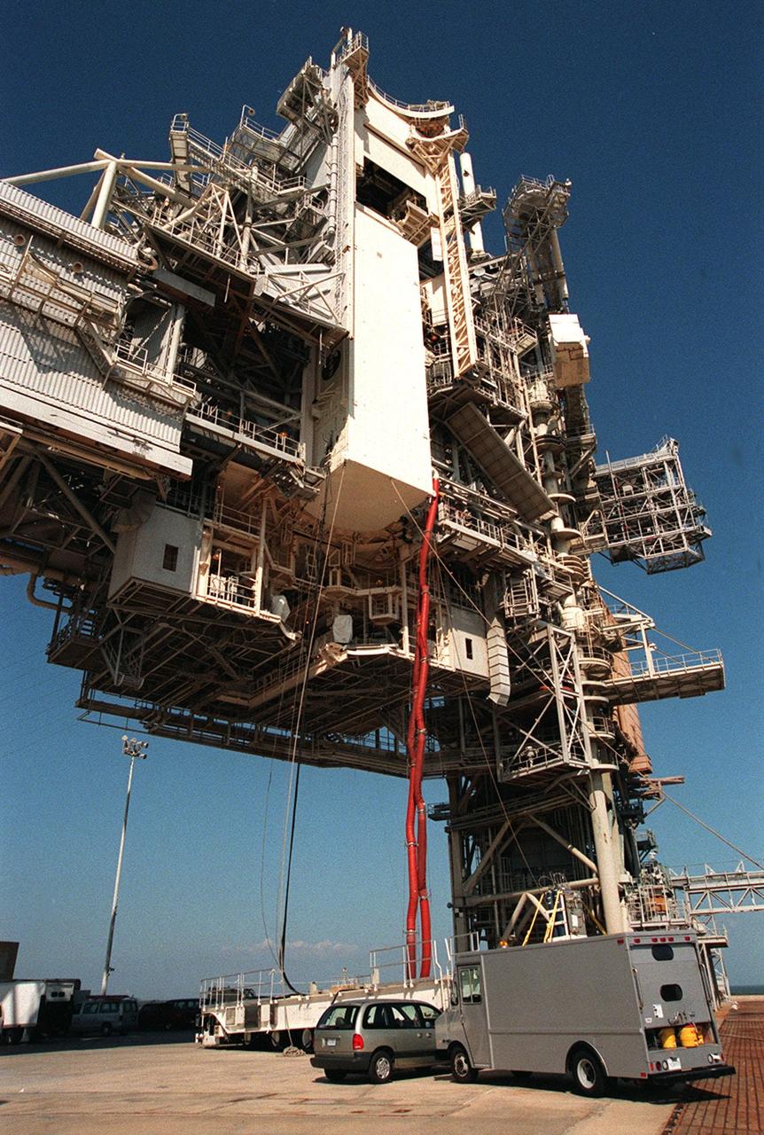 KENNEDY SPACE CENTER, FLA. -- At Launch Pad 39B, the payload canister for Space Shuttle Discovery, for mission STS-103, is lifted up the Rotating Service Structure. The hoses attached to the canister provide airconditioning until the canister is mated to the environmentally controlled Payload Changeout Room and the payload bay doors are open. Installation of the payload into Discovery is slated for Friday, Nov. 12. The mission is a "call-up" due to the need to replace portions of the pointing system, the gyros, which have begun to fail on the Hubble Space Telescope. Although Hubble is operating normally and conducting its scientific observations, only three of its six gyroscopes are working properly. The gyroscopes allow the telescope to point at stars, galaxies and planets. The STS-103 crew will also be replacing a Fine Guidance Sensor and an older computer with a new enhanced model, an older data tape recorder with a solid-state digital recorder, a failed spare transmitter with a new one, and degraded insulation on the telescope with new thermal insulation. The crew will also install a Battery Voltage/Temperature Improvement Kit to protect the spacecraft batteries from overcharging and overheating when the telescope goes into a safe mode