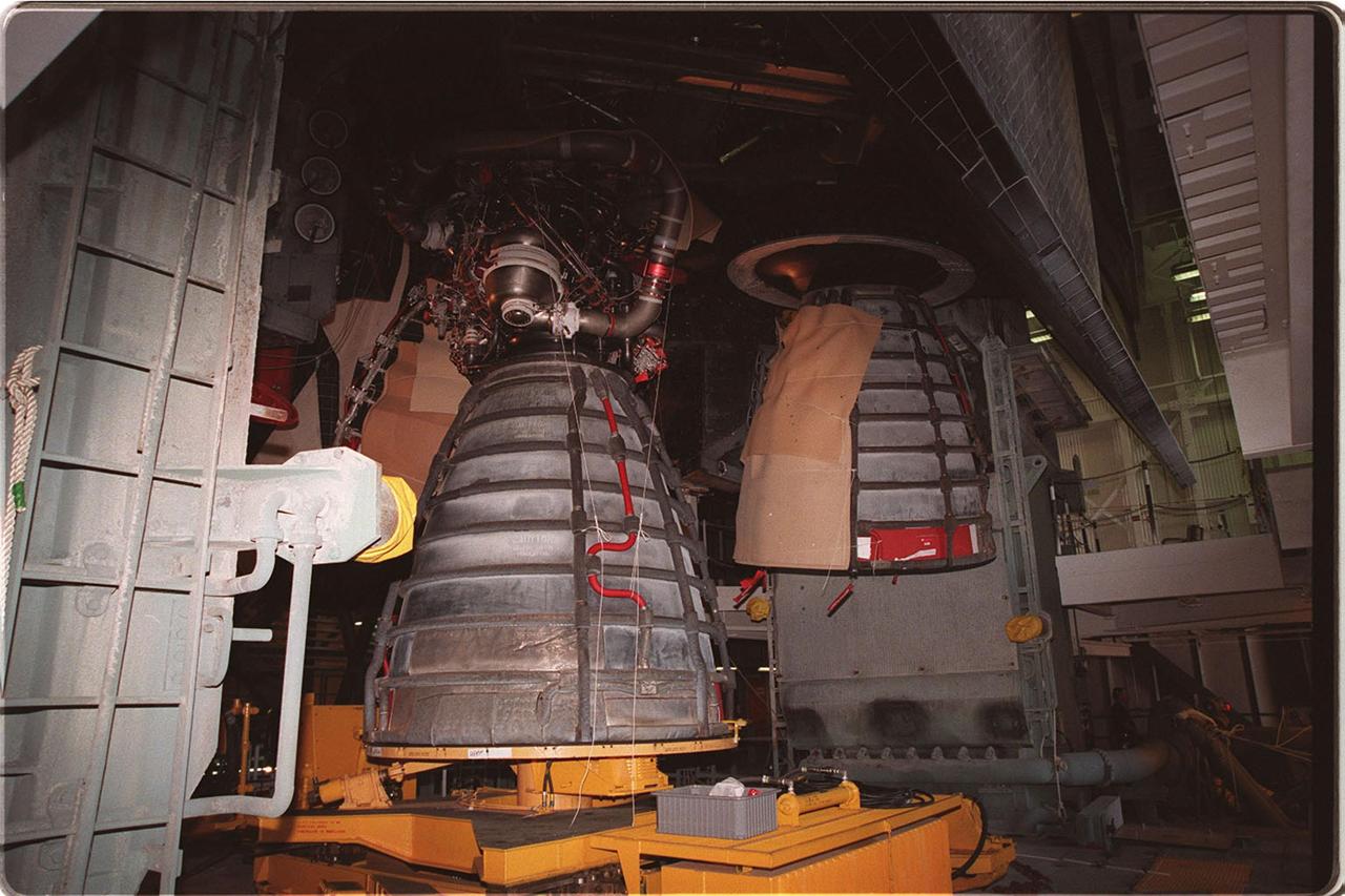 KENNEDY SPACE CENTER, FLA. --  Inside the Vehicle Assembly Building, main engine No. 3 (left) is being removed from Space Shuttle Discovery. Last week, Shuttle managers determined that the engine was not acceptable for flight because a half-inch-long broken drill bit is lodged in the engine's coolant cavity. Therefore, the engine is being replaced. The Shuttle is expected to roll out to the pad at 2 a.m. Saturday morning, Nov. 13. The STS-103 launch is now targeted for Dec. 6 at 2:37 a.m. EST. The 10-day mission is expected to conclude at KSC on Dec. 16 with a 12:45 a.m. landing