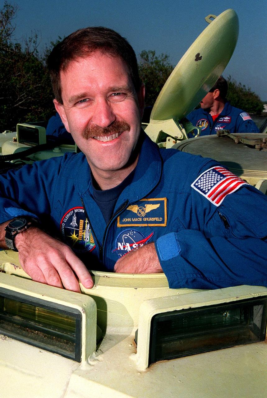 STS-103 Mission Specialist John M. Grunsfeld (Ph.D.) gets ready to take the wheel of a small armored personnel carrier that is part of emergency egress training during Terminal Countdown Demonstration Test (TCDT) activities. The tracked vehicle could be used by the crew in the event of an emergency at the pad during which the crew must make a quick exit from the area. The TCDT also provides simulated countdown exercises and opportunities to inspect the mission payloads in the orbiter's payload bay. STS-103 is a "call-up" mission due to the need to replace and repair portions of the Hubble Space Telescope. Four EVA's are planned to make the necessary repairs and replacements on the telescope. The other STS-103 crew members are Commander Curtis L. Brown Jr., Pilot Scott J. Kelly, and Mission Specialists Steven L. Smith, C. Michael Foale (Ph.D.), (Ph.D.), plus Claude Nicollier of Switzerland and Jean-François Clervoy of France, who are with the European Space Agency. The mission is targeted for launch Dec. 6 at 2:37 a.m. EST