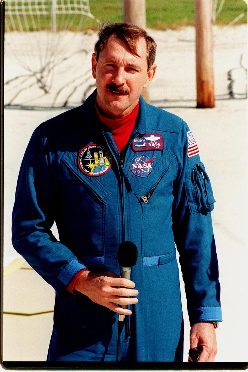 STS-103 Commander Curtis L. Brown Jr. answers a question from the media about the mission. As a preparation for launch, the crew have been participating in Terminal Countdown Demonstration Test (TCDT) activities at KSC. The TCDT provides the crew with emergency egress training, opportunities to inspect their mission payloads in the orbiter's payload bay, and simulated countdown exercises. Other crew members are Pilot Scott J. Kelly, and Mission Specialists Steven L. Smith, Jean-François Clervoy of France, who is with the European Space Agency (ESA), John M. Grunsfeld (Ph.D.), C. Michael Foale (Ph.D.), and Claude Nicollier of Switzerland, who is also with ESA. STS-103 is a "call-up" mission due to the need to replace and repair portions of the Hubble Space Telescope, including the gyroscopes that allow the telescope to point at stars, galaxies and planets. The STS-103 crew will be replacing a Fine Guidance Sensor, an older computer with a new enhanced model, an older data tape recorder with a solid-state digital recorder, a failed spare transmitter with a new one, and degraded insulation on the telescope with new thermal insulation. The crew will also install a Battery Voltage/Temperature Improvement Kit to protect the spacecraft batteries from overcharging and overheating when the telescope goes into a safe mode. Four EVA's are planned to make the necessary repairs and replacements on the telescope. The mission is targeted for launch Dec. 6 at 2:37 a.m. EST