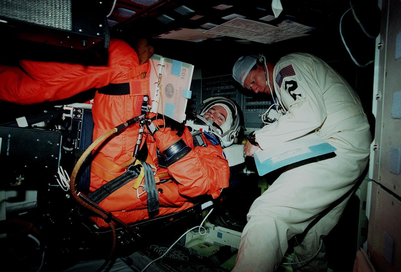 STS-103 Mission Specialists Jean-François Clervoy of France takes his seat inside the Space Shuttle Discovery during a practice launch countdown, part of Terminal Countdown Demonstration Test (TCDT) activities, while astronaut David "Doc" Brown checks him out. The TCDT also provides the crew with emergency egress training and opportunities to inspect their mission payload in the orbiter's payload bay. Other crew members taking part in the TCDT are Commander Curtis L. Brown Jr., Pilot Scott J. Kelly, and Mission Specialists Steven L. Smith, C. Michael Foale (Ph.D.), John M. Grunsfeld (Ph.D.), and Claude Nicollier of Switzerland. Clervoy and Nicollier are with the European Space Agency. STS-103 is a "call-up" mission due to the need to replace and repair portions of the Hubble Space Telescope, including the gyroscopes that allow the telescope to point at stars, galaxies and planets. The STS-103 crew will be replacing a Fine Guidance Sensor, an older computer with a new enhanced model, an older data tape recorder with a solid-state digital recorder, a failed spare transmitter with a new one, and degraded insulation on the telescope with new thermal insulation. The crew will also install a Battery Voltage/Temperature Improvement Kit to protect the spacecraft batteries from overcharging and overheating when the telescope goes into a safe mode. Four EVA's are planned to make the necessary repairs and replacements on the telescope. The mission is targeted for launch Dec. 6 at 2:37 a.m. EST