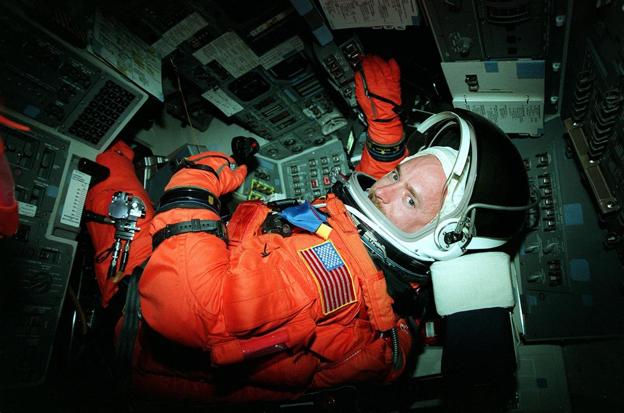 Seated in the orbiter Discovery for a simulated countdown exercise is STS-103 Pilot Scott J. Kelly. The simulation is part of Terminal Countdown Demonstration Test (TCDT) activities. The TCDT also provides the crew with emergency egress training and opportunities to inspect their mission payload in the orbiter's payload bay. Other crew members taking part in the TCDT are Commander Curtis L. Brown Jr., and Mission Specialists Steven L. Smith, C. Michael Foale (Ph.D.), John M. Grunsfeld (Ph.D.), Jean-François Clervoy of France, and Claude Nicollier of Switzerland. Clervoy and Nicollier are with the European Space Agency. STS-103 is a "call-up" mission due to the need to replace and repair portions of the Hubble Space Telescope, including the gyroscopes that allow the telescope to point at stars, galaxies and planets. The STS-103 crew will be replacing a Fine Guidance Sensor, an older computer with a new enhanced model, an older data tape recorder with a solid-state digital recorder, a failed spare transmitter with a new one, and degraded insulation on the telescope with new thermal insulation. The crew will also install a Battery Voltage/Temperature Improvement Kit to protect the spacecraft batteries from overcharging and overheating when the telescope goes into a safe mode. Four EVA's are planned to make the necessary repairs and replacements on the telescope. The mission is targeted for launch Dec. 6 at 2:37 a.m. EST