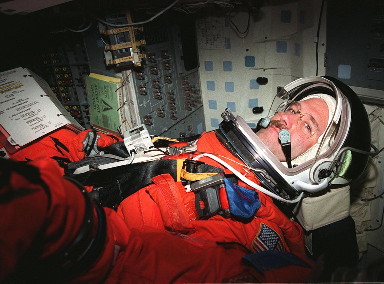 STS-103 Mission Specialist John M. Grunsfeld (Ph.D.) sits inside orbiter Discovery waiting for the start of a simulated countdown exercise. The simulation is part of Terminal Countdown Demonstration Test (TCDT) activities. The TCDT also provides the crew with emergency egress training and opportunities to inspect their mission payload in the orbiter's payload bay. Other crew members taking part in the TCDT are Commander Curtis L. Brown Jr., Pilot Scott J. Kelly, and Mission Specialists Steven L. Smith, C. Michael Foale (Ph.D.), Jean-François Clervoy of France, and Claude Nicollier of Switzerland. Clervoy and Nicollier are with the European Space Agency. STS-103 is a "call-up" mission due to the need to replace and repair portions of the Hubble Space Telescope, including the gyroscopes that allow the telescope to point at stars, galaxies and planets. The STS-103 crew will be replacing a Fine Guidance Sensor, an older computer with a new enhanced model, an older data tape recorder with a solid-state digital recorder, a failed spare transmitter with a new one, and degraded insulation on the telescope with new thermal insulation. The crew will also install a Battery Voltage/Temperature Improvement Kit to protect the spacecraft batteries from overcharging and overheating when the telescope goes into a safe mode. Four EVA's are planned to make the necessary repairs and replacements on the telescope. The mission is targeted for launch Dec. 6 at 2:37 a.m. EST