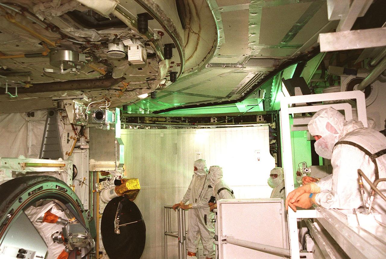 KENNEDY SPACE CENTER, FLA. -- Members of the STS-103 crew, with representatives from Goddard Space Flight Center, look over the Hubble servicing cargo in the payload bay of Space Shuttle Discovery at Launch Pad 39B. From left are Mission Specialist Steven L. Smith and Claude Nicollier of Switzerland; Steve Pataki and Dave Southwick, with Goddard; and Mission Commander Curtis L. Brown Jr. Inspecting the payload is part of the Terminal Countdown Demonstration Test (TCDT), which also provides the crew with emergency egress training and a simulated countdown exercise. Other crew members taking part in the TCDT are Pilot Scott J. Kelly, and Mission Specialists C. Michael Foale (Ph.D.), John M. Grunsfeld (Ph.D.), and Jean-François Clervoy of France. Clervoy and Nicollier are with the European Space Agency. STS-103 is a "call-up" mission due to the need to replace and repair portions of the Hubble Space Telescope, including the gyroscopes that allow the telescope to point at stars, galaxies and planets. The STS-103 crew will be replacing a Fine Guidance Sensor, an older computer with a new enhanced model, an older data tape recorder with a solid-state digital recorder, a failed spare transmitter with a new one, and degraded insulation on the telescope with new thermal insulation. The crew will also install a Battery Voltage/Temperature Improvement Kit to protect the spacecraft batteries from overcharging and overheating when the telescope goes into a safe mode. Four EVA's are planned to make the necessary repairs and replacements on the telescope. The mission is targeted for launch Dec. 6 at 2:37 a.m. EST