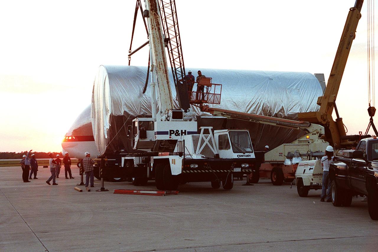 KENNEDY SPACE CENTER, FLA. -- Workers secure the P3 truss on the transporter for the trip to the Operations and Checkout Building. The second port-side truss is a segment of the International Space Station (ISS), scheduled to be added to the ISS on mission STS-115 in 2002 aboard Space Shuttle Atlantis. P3 will be attached to the first port truss segment (P1).