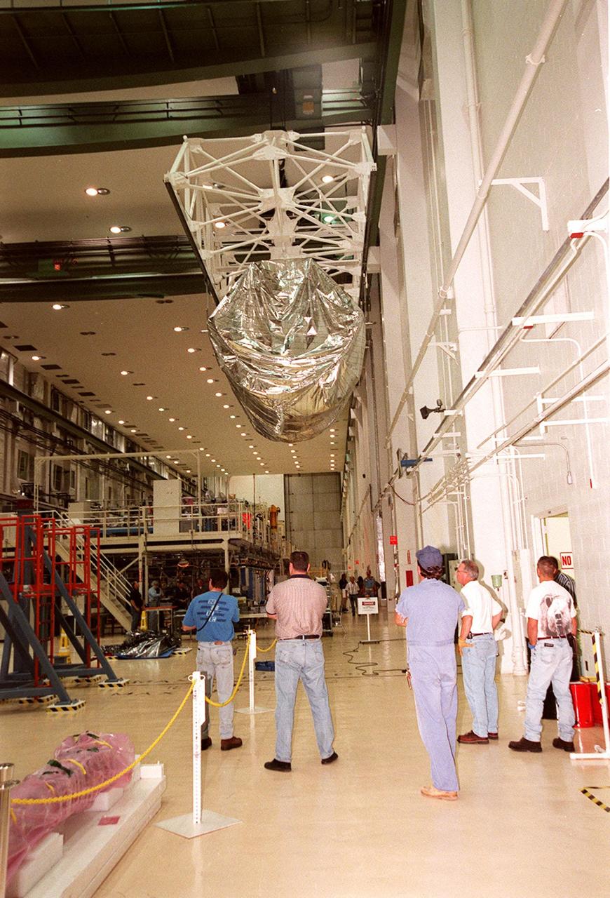 KENNEDY SPACE CENTER, FLA. -- Inside the Operations and Checkout Building, overhead cranes move a segment of the International Space Station (ISS), the port-side P3 truss, toward a workstand. The truss is scheduled to be added to the ISS on mission STS-115 in 2002 aboard Space Shuttle Atlantis. The second port truss segment, P3 will be attached to the first port truss segment (P1).