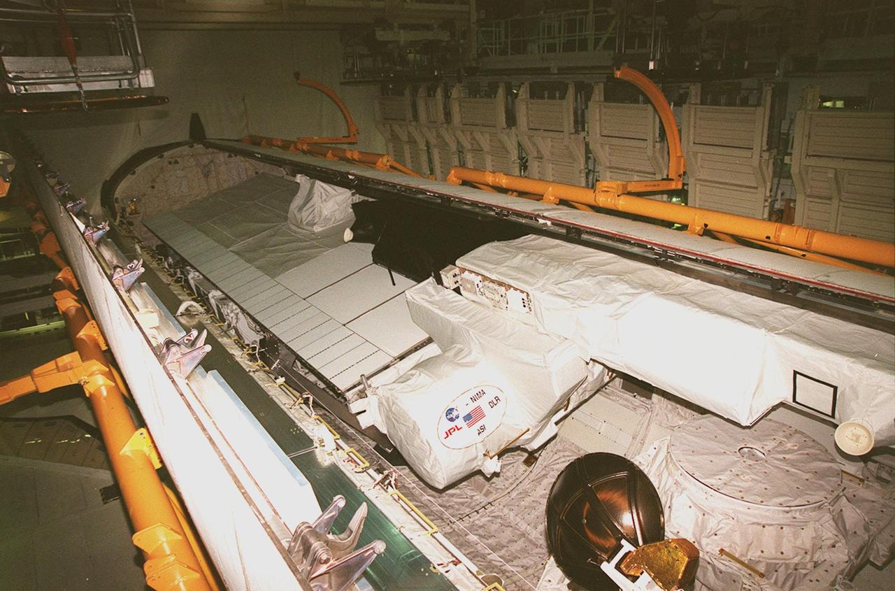 KENNEDY SPACE CENTER, FLA. -- Viewed end to end, the interior of orbiter Endeavour's payload bay can be seen with its cargo (center and right) in place, before the close of its payload bay doors. The Ku-band antenna (lower right) is now in its closed position inside the payload bay. Endeavour is expected to roll over to the Vehicle Assembly Building in three days for mating to the external tank and solid rocket boosters in high bay 1. Space Shuttle Endeavour is targeted for launch on mission STS-99 Jan. 13, 2000 at 1:11 p.m. EST. STS-99 is the Shuttle Radar Topography Mission, an international project spearheaded by the National Imagery and Mapping Agency and NASA, with participation of the German Aerospace Center DLR. The SRTM consists of a specially modified radar system that will gather data for the most accurate and complete topographic map of the Earth's surface that has ever been assembled. SRTM will make use of radar interferometry, wherein two radar images are taken from slightly different locations. Differences between these images allow for the calculation of surface elevation, or change. The SRTM hardware will consist of one radar antenna in the shuttle payload bay and a second radar antenna attached to the end of a mast extended 60 meters (195 feet) out from the shuttle
