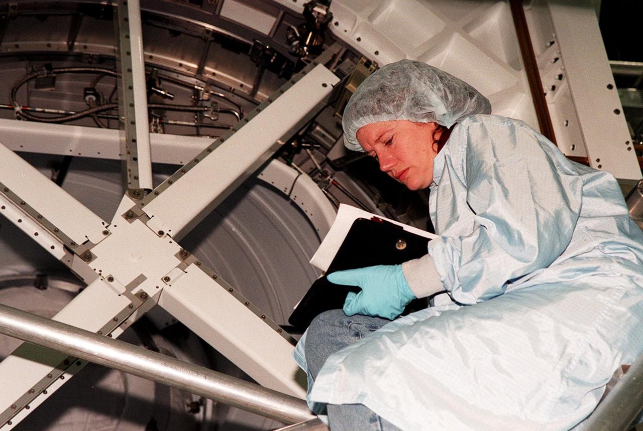 KENNEDY SPACE CENTER, FLA. -- STS-102 crew member Susan J. Helms looks over a Pressurized Mating Adapter (PMA-3) in the Space Station Processing Facility. The PMA-3 is a component of the International Space Station (ISS). Helms is one of three who will be staying on the ISS as the Expedition II crew. The others are Yuriy Vladimirovich Usachev and James S. Voss. Along with the crew, Mission STS-102 also will be carrying the Leonardo Multi-Purpose Logistics Module (MPLM) to the ISS. The Leonardo will be filled with equipment and supplies to outfit the U.S. laboratory module, which will have been carried to the ISS on a preceding Shuttle flight. In order to function as an attached station module as well as a cargo transport, logistics modules (there are three) also include components that provide some life support, fire detection and suppression, electrical distribution and computer functions. Eventually, the modules also will carry refrigerator freezers for transporting experiment samples and food to and from the station. On the return of STS-102 to Earth, it will bring back the first crew on the station: Bill Shepherd, Sergei Krikalev and Yuri Gidzenko. STS-102 is scheduled to launch no earlier than Oct. 19, 2000, from Launch Pad 39A, Kennedy Space Center