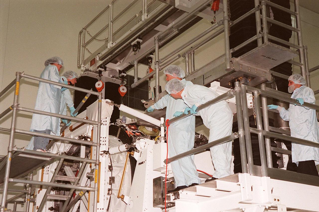 KENNEDY SPACE CENTER, FLA. -- Members of the STS-102 crew, known as the Expedition II crew, and workers from Johnson Space Center get a close look at the Pressurized Mating Adapter (PMA-3) in the Space Station Processing Facility. The PMA-3 is a component of the International Space Station (ISS). Making up the Expedition II crew are James S. Voss, Susan J. Helms and Yuriy Vladimirovich Usachev, of Russia. Along with the crew, Mission STS-102 also will be carrying the Leonardo Multi-Purpose Logistics Module (MPLM) to the ISS. The Leonardo will be filled with equipment and supplies to outfit the U.S. laboratory module, which will have been carried to the ISS on a preceding Shuttle flight. In order to function as an attached station module as well as a cargo transport, logistics modules (there are three) also include components that provide some life support, fire detection and suppression, electrical distribution and computer functions. Eventually, the modules also will carry refrigerator freezers for transporting experiment samples and food to and from the station. On the return of STS-102 to Earth, it will bring back the first crew on the station: Bill Shepherd, Sergei Krikalev and Yuri Gidzenko. STS-102 is scheduled to launch no earlier than Oct. 19, 2000, from Launch Pad 39A, Kennedy Space Center