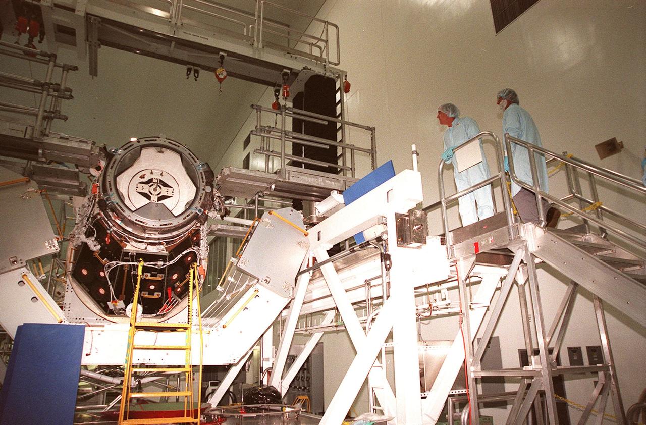 KENNEDY SPACE CENTER, FLA. -- From a work stand in the Space Station Processing Facility, STS-102 crew members James S. Voss (left) and Yuriy Vladimirovich Usachev (right), of Russia, look over the Pressurized Mating Adapter (PMA-3). The PMA-3 is a component of the International Space Station (ISS). Voss and Usachev are two crew members who will be staying on the ISS as the Expedition II crew. The third is Susan J. Helms. Along with the crew, Mission STS-102 also will be carrying the Leonardo Multi-Purpose Logistics Module (MPLM) to the ISS. The Leonardo will be filled with equipment and supplies to outfit the U.S. laboratory module, which will have been carried to the ISS on a preceding Shuttle flight. In order to function as an attached station module as well as a cargo transport, logistics modules (there are three) also include components that provide some life support, fire detection and suppression, electrical distribution and computer functions. Eventually, the modules also will carry refrigerator freezers for transporting experiment samples and food to and from the station. On the return of STS-102 to Earth, it will bring back the first crew on the station: Bill Shepherd, Sergei Krikalev and Yuri Gidzenko. STS-102 is scheduled to launch no earlier than Oct. 19, 2000, from Launch Pad 39A, Kennedy Space Center