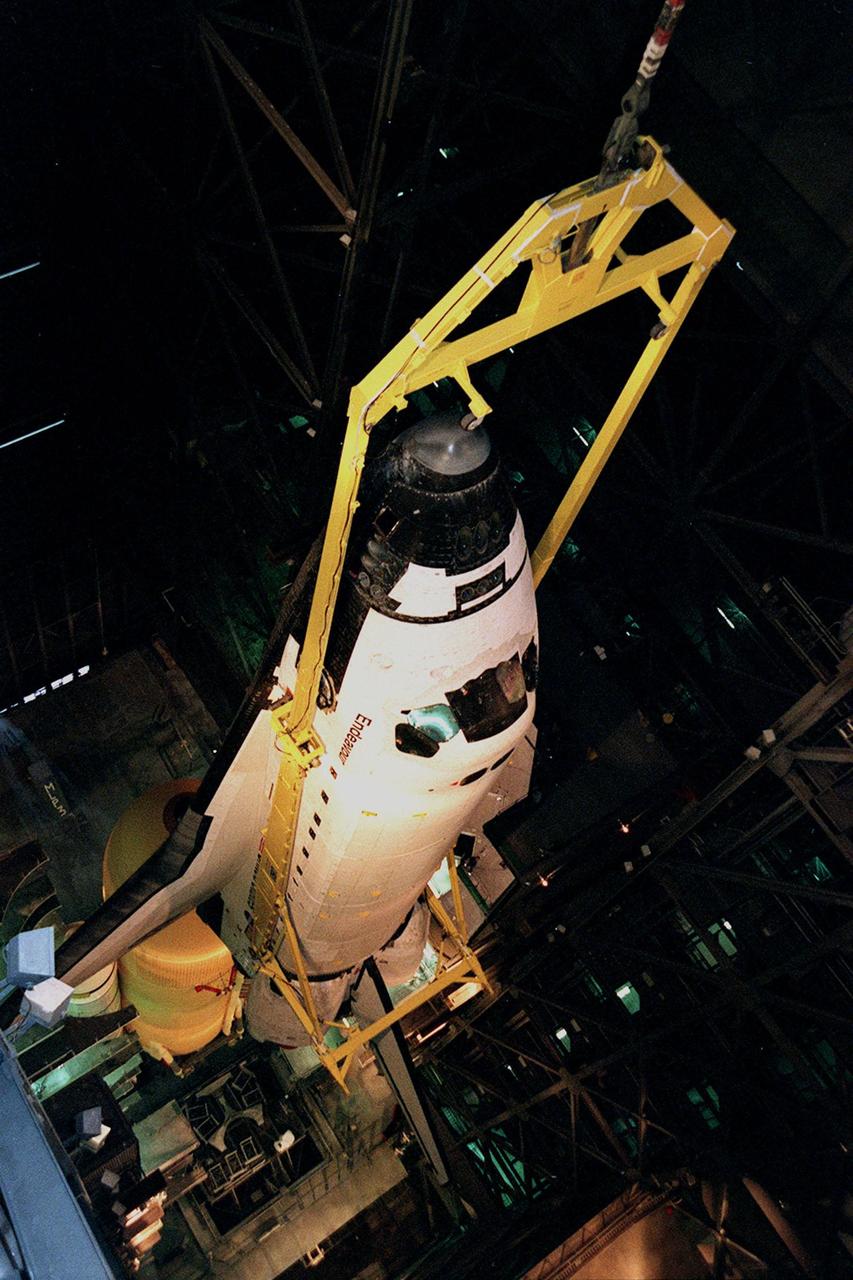KENNEDY SPACE CENTER, FLA. -- In this dizzying view from overhead in high bay 1 of the VAB, the orbiter Endeavour is lowered for mating with the external tank below (on left), and the solid rocket boosters. Space Shuttle Endeavour is targeted for launch on mission STS-99 Jan. 13, 2000, at 1:11 p.m. EST. STS-99 is the Shuttle Radar Topography Mission, an international project spearheaded by the National Imagery and Mapping Agency and NASA, with participation of the German Aerospace Center DLR. The SRTM consists of a specially modified radar system that will gather data for the most accurate and complete topographic map of the Earth's surface that has ever been assembled. SRTM will make use of radar interferometry, wherein two radar images are taken from slightly different locations. Differences between these images allow for the calculation of surface elevation, or change. The SRTM hardware will consist of one radar antenna in the shuttle payload bay and a second radar antenna attached to the end of a mast extended 60 meters (195 feet) out from the shuttle