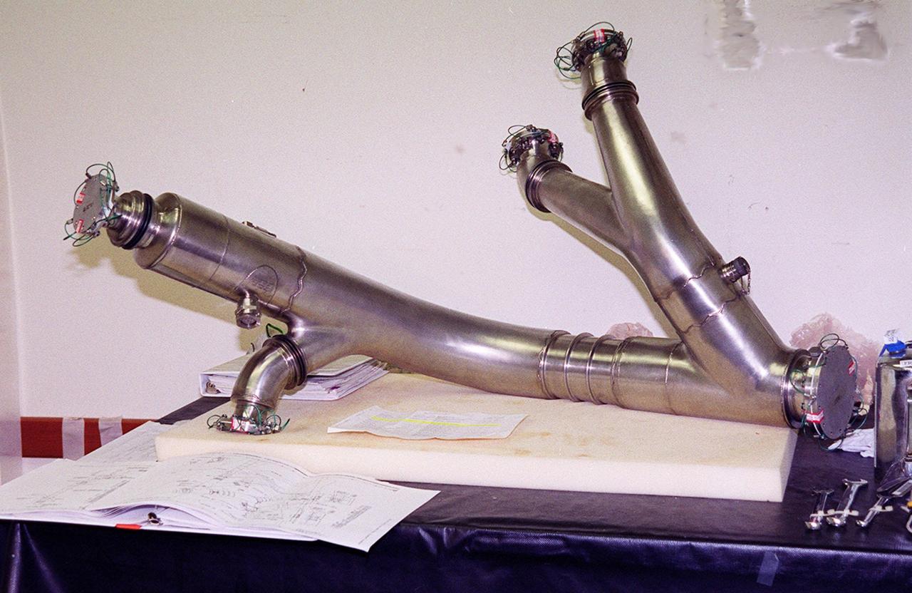 A spare four-inch diameter LH2 recirculation line (shown in photo) will be used to replace a damaged LH2 line in the orbiter Discovery. The line recirculates hydrogen from the Shuttle main engines back to the external tank during prelaunch engine conditioning. Workers noted a dent in the line during routine aft compartment inspections Tuesday, Dec. 7. The dent measures 12 inches long and about ½-inch deep. Managers expect the replacement work to take about 3 days, followed by system retests and final aft compartment close-outs. Preliminary assessments reflect a launch date of Space Shuttle Discovery on mission STS-103 no earlier than Dec. 16. STS-103 is the third servicing mission for the Hubble Space Telescope