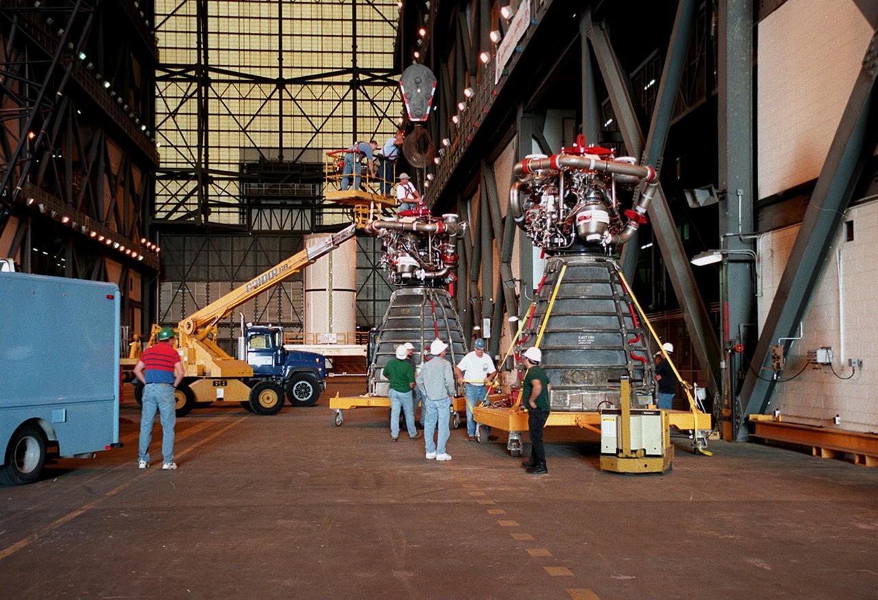 KENNEDY SPACE CENTER, FLA. -- Workers in the Vehicle Assembly Building move orbiter Endeavour's main engine No. 3 (in front) out of the way before moving the replacement engine into place. Following routine testing procedures on a separate test engine, analysis revealed delamination on the wall of the engine's main combustion chamber. When data revealed that one of Endeavour's engines had undergone similar testing procedures, managers opted to replace the suspect engine as a precaution. Space Shuttle Endeavour is targeted for launch on mission STS-99 on Jan. 13, 2000, at 1:11 p.m. EST. STS-99 is the Shuttle Radar Topography Mission