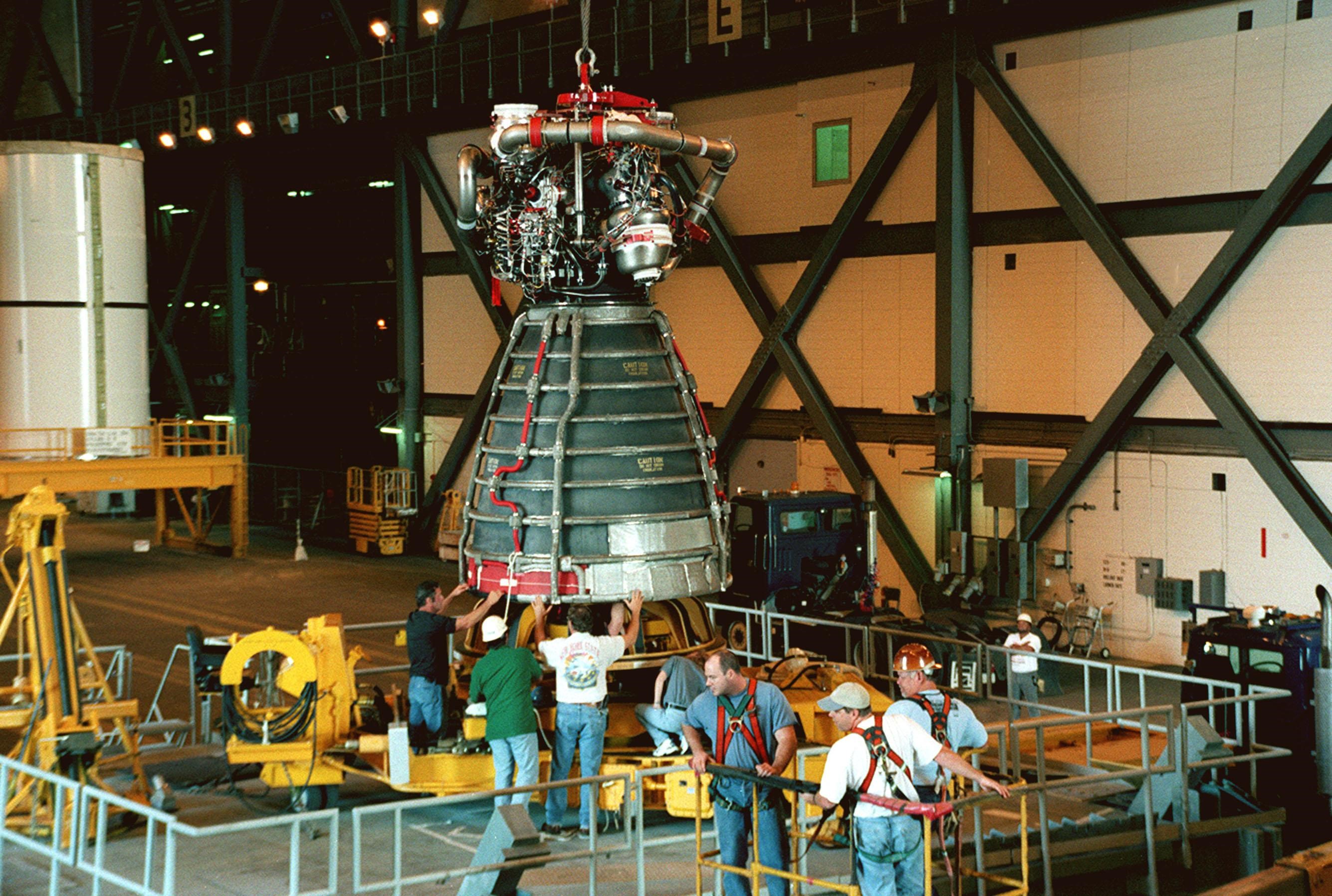 KENNEDY SPACE CENTER, FLA. -- Workers in the Vehicle Assembly Building move orbiter Endeavour's replacement main engine No. 3 onto a work stand to prepare it for installation in the orbiter. Following routine testing procedures on a separate test engine, analysis revealed delamination on the wall of the engine's main combustion chamber. When data revealed that one of Endeavour's engines had undergone similar testing procedures, managers opted to replace the suspect engine as a precaution. Space Shuttle Endeavour is targeted for launch on mission STS-99 on Jan. 13, 2000, at 1:11 p.m. EST. STS-99 is the Shuttle Radar Topography Mission
