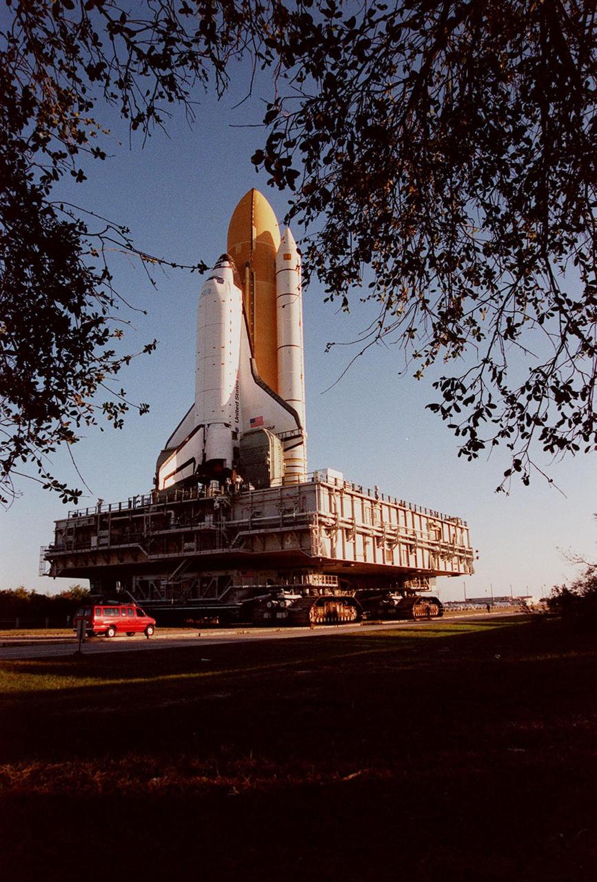 KENNEDY SPACE CENTER, Fla. -- Framed by branches of oak leaves in this photo, Space Shuttle Endeavour, on its mobile launcher platform, is transferred to Launch Pad 39A for mission STS-99. The van behind it is barely noticeable next to the gigantic stature of the moving vehicle. Named the Shuttle Radar Topography Mission (SRTM), it involves an international project spearheaded by the National Imagery and Mapping Agency and NASA, with participation of the German Aerospace Center DLR. The SRTM consists of a specially modified radar system that will gather data for the most accurate and complete topographic map of the Earth's surface that has ever been assembled