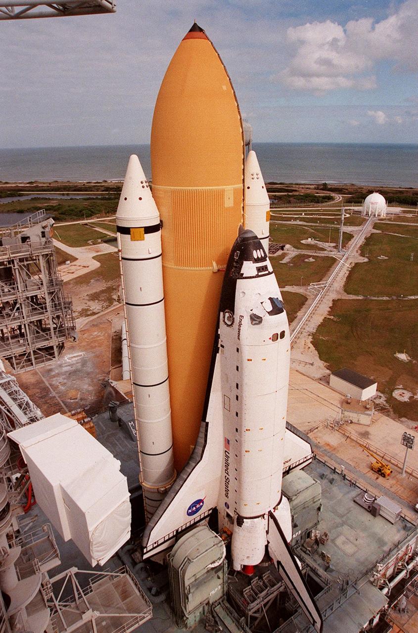 KENNEDY SPACE CENTER, Fla. -- Under partly cloudy skies and the Atlantic Ocean as a backdrop, Space Shuttle Endeavour, atop the mobile launcher platform, arrives at Launch Pad 39A for mission STS-99. The white cubicle at left is the environmental chamber, the White Room, that provides entry into the orbiter for the astronauts. It is at the outer end of the Orbiter Access Arm on the Fixed Service Structure. STS-99, named the Shuttle Radar Topography Mission (SRTM), involves an international project spearheaded by the National Imagery and Mapping Agency and NASA, with participation of the German Aerospace Center DLR. SRTM will chart a new course, using two antennae and a 200-foot-long section of space station-derived mast protruding from its payload bay, to produce unrivaled 3-D images of the Earth's surface. The result of the Shuttle Radar Topography Mission could be close to 1 trillion measurements of the Earth's topography. Besides contributing to the production of better maps, these measurements could lead to improved water drainage modeling, more realistic flight simulators, better locations for cell phone towers, and enhanced navigation safety. STS-99 is scheduled for launch in January 2000
