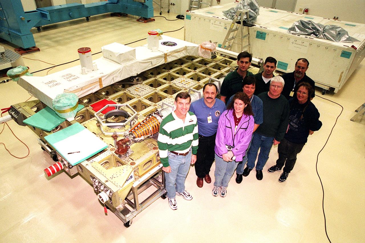 KENNEDY SPACE CENTER, FLA. -- At SPACEHAB, in Titusville, Fla., members of the STS-102 crew pose for a photograph with SPACEHAB workers in front of the International Cargo Carrier, which will carry cargo to the International Space Station (ISS). The crew are, left to right, Mission Specialists James Voss, Yuri Usachev, who is with the Russian Space Agency (RSA), and Susan Helms. STS-102 is a resupply mission to the International Space Station, transporting the Leonardo Multi-Purpose Logistics Module (MPLM) with equipment to assist in outfitting the U.S. Lab, which will already be in place. The mission is also transporting Helms, Voss and Usachev as the second resident crew (designated Expedition crew 2) to the station. In exchange, the mission will return to Earth the first expedition crew on ISS: William Shepherd, Sergei Krikalev (RSA) and Yuri Gidzenko (RSA). STS-102 is scheduled to launch no earlier than Oct. 19, 2000