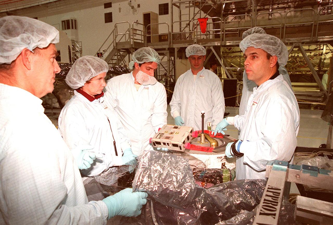 STS-102 crew members at left are briefed by workers (right) in the Space Station Processing Facility (SSPF) on equipment for their mission. From left are Mission Specialists James Voss, Susan Helms and Yuri Usachev, with the Russian Space Agency (RSA). STS-102 is a resupply mission to the International Space Station, transporting the Leonardo Multi-Purpose Logistics Module (MPLM) with equipment to assist in outfitting the U.S. Lab, which will already be in place. The mission is also transporting Helms, Voss and Usachev as the second resident crew (designated Expedition crew 2) to the station. In exchange, the mission will return to Earth the first expedition crew on ISS: William Shepherd, Sergei Krikalev (RSA) and Yuri Gidzenko (RSA). STS-102 is scheduled to launch no earlier than Oct. 19, 2000