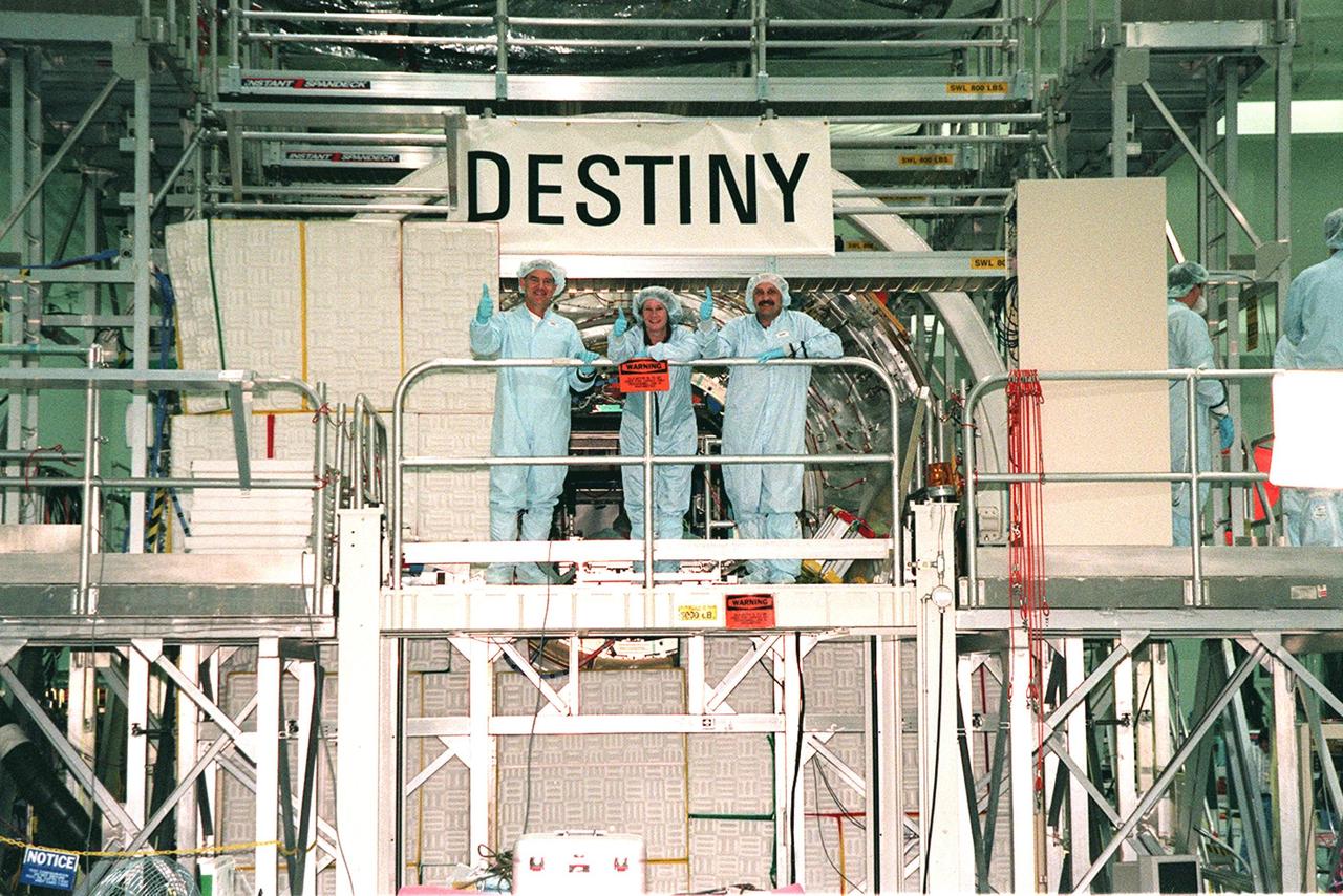 STS-102 Mission Specialists James Voss, Susan Helms and Yuri Usachev, with the Russian Space Agency (RSA), pose in front of the U.S. Lab module, named Destiny, in the Space Station Processing Facility (SSPF). STS-102 is a resupply mission to the International Space Station, transporting the Leonardo Multi-Purpose Logistics Module (MPLM) with equipment to assist in outfitting the U.S. Lab, which will already be in place. The mission is also transporting Helms, Voss and Usachev as the second resident crew (designated Expedition crew 2) to the station. In exchange, the mission will return to Earth the first expedition crew on ISS: William Shepherd, Sergei Krikalev (RSA) and Yuri Gidzenko (RSA). STS-102 is scheduled to launch no earlier than Oct. 19, 2000