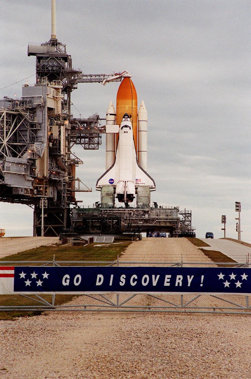 As dawn breaks at Launch Pad 39B on the east coast of Florida, the Space Shuttle Discovery is revealed poised for flight on mission STS-103. The rollback of the Rotating Service Structure (left) was complete at 4:46 a.m. EST. STS-103 is scheduled for launch Dec. 16 at 9:18 p.m. EST. The mission is expected to last about 9 days and 21 hours with a landing at KSC Sunday, Dec. 26, at 6:56 p.m. EST