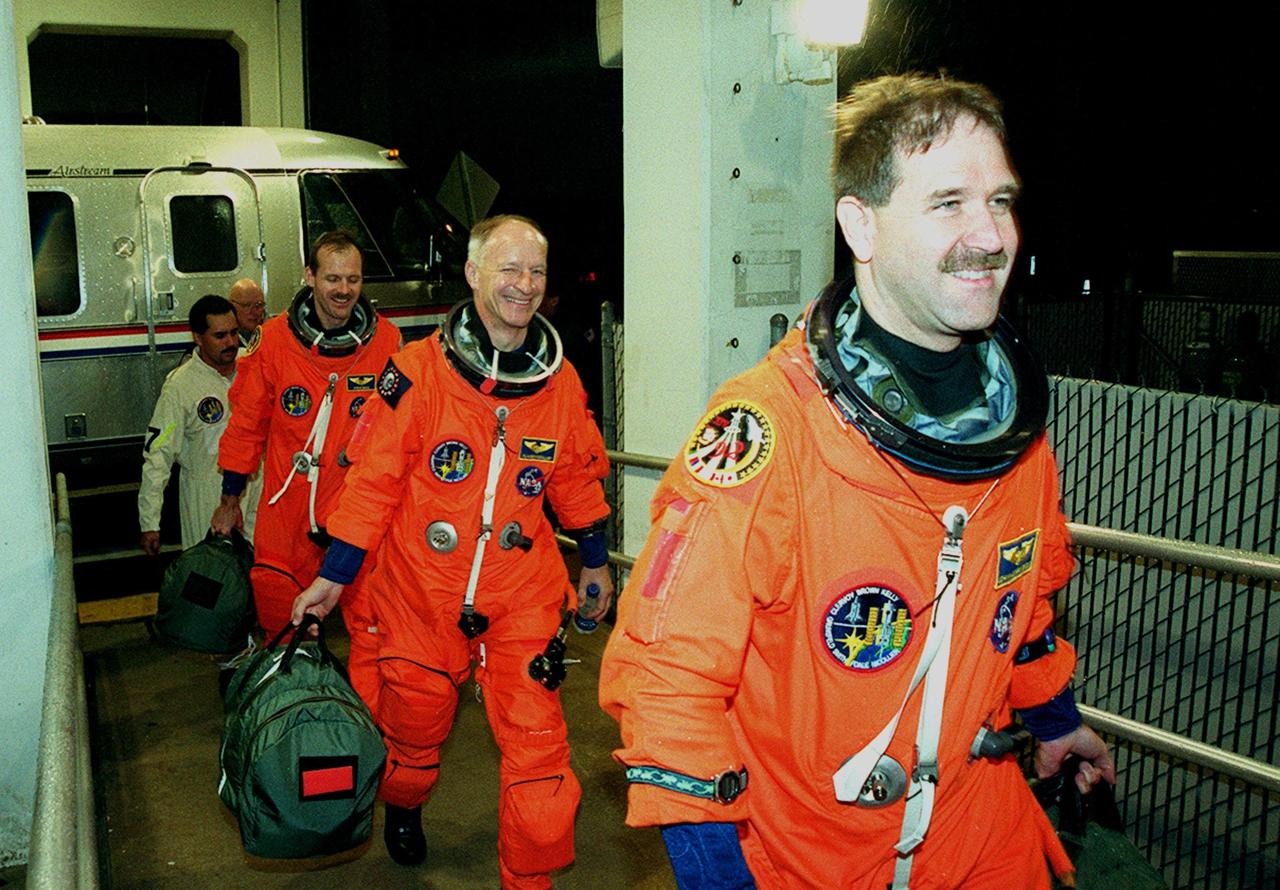 STS-103 crew members head back to the Operations and Checkout Building after the launch of Space Shuttle Discovery was scrubbed due to unfavorable weather conditions. In the lead (right) is Mission Specialist John M. Grunsfeld (Ph.D.), followed by Mission Specialists Claude Nicollier of Switzerland and Steven L. Smith. . Other crew members are Commander Curtis L. Brown Jr., Pilot Scott J. Kelly, and Mission Specialists C. Michael Foale (Ph.D.) and Jean-Francois Clervoy of France. Nicollier and Clervoy are with the European Space Agency. The STS-103 mission, to service the Hubble Space Telescope, is rescheduled for launch Dec. 18 at 8:21 p.m. EST from Launch Pad 39B. Mission objectives include replacing gyroscopes and an old computer, installing another solid state recorder, and replacing damaged insulation in the telescope. After the 7-day, 21-hour mission, Discovery is expected to land at KSC Sunday, Dec. 26, at about 6:00 p.m. EST