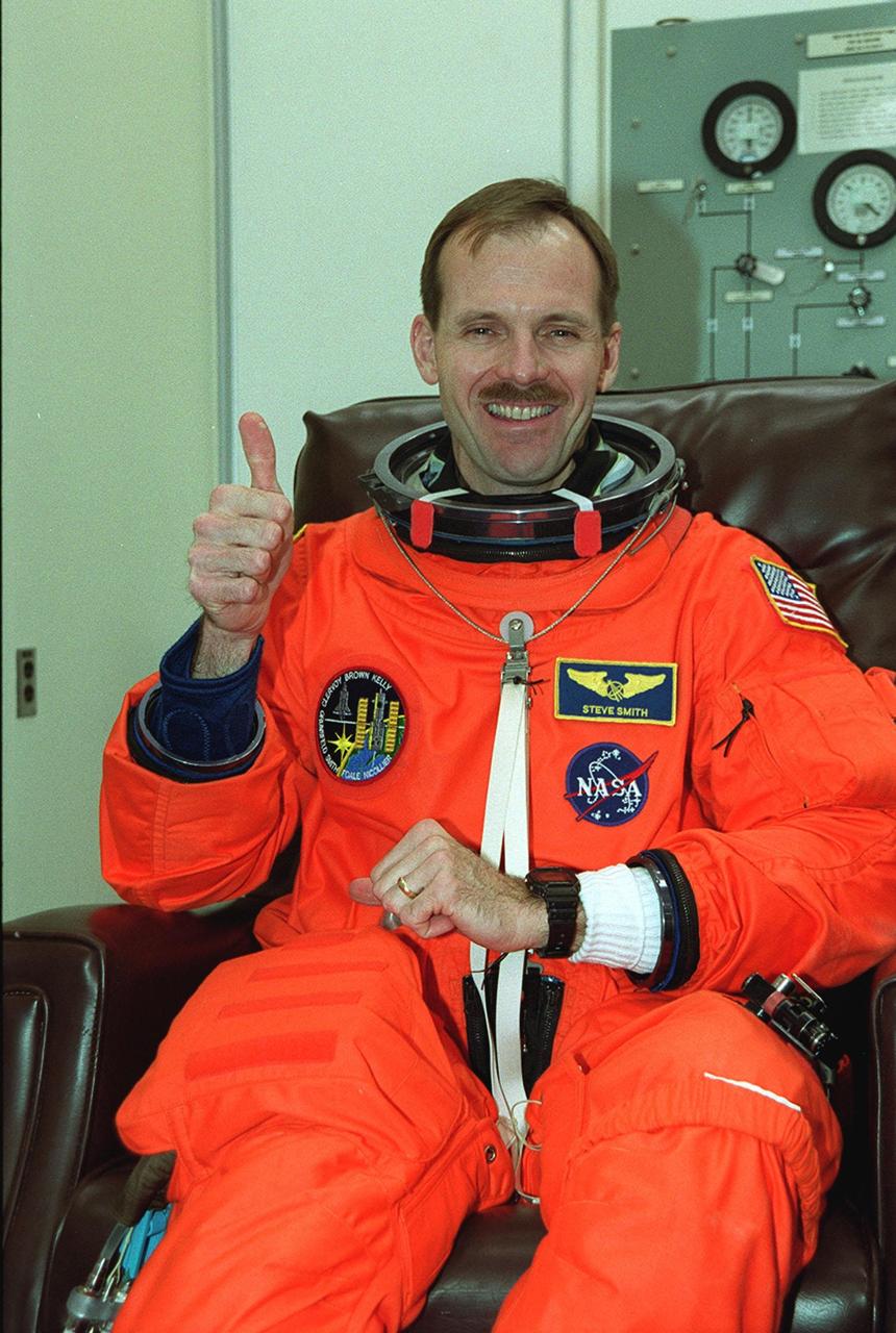 After donning his launch and entry suit, STS-103 Mission Specialist Steven L. Smith shows a positive attitude over the second launch attempt for Space Shuttle Discovery. The previous launch attempt on Dec. 17 was scrubbed about 8:52 p.m. due to numerous violations of weather launch commit criteria at KSC. Smith and other crew members Commander Curtis L. Brown Jr., Pilot Scott J. Kelly and Mission Specialists C. Michael Foale (Ph.D.), John M. Grunsfeld (Ph.D.), Claude Nicollier of Switzerland and Jean-Francois Clervoy of France are scheduled to lift off at 7:50 p.m. EST Dec. 19 on mission STS-103, servicing the Hubble Space Telescope. Objectives for the nearly eight-day mission include replacing gyroscopes and an old computer, installing another solid state recorder, and replacing damaged insulation in the telescope. Discovery is expected to land at KSC Monday, Dec. 27, at about 5:24 p.m. EST