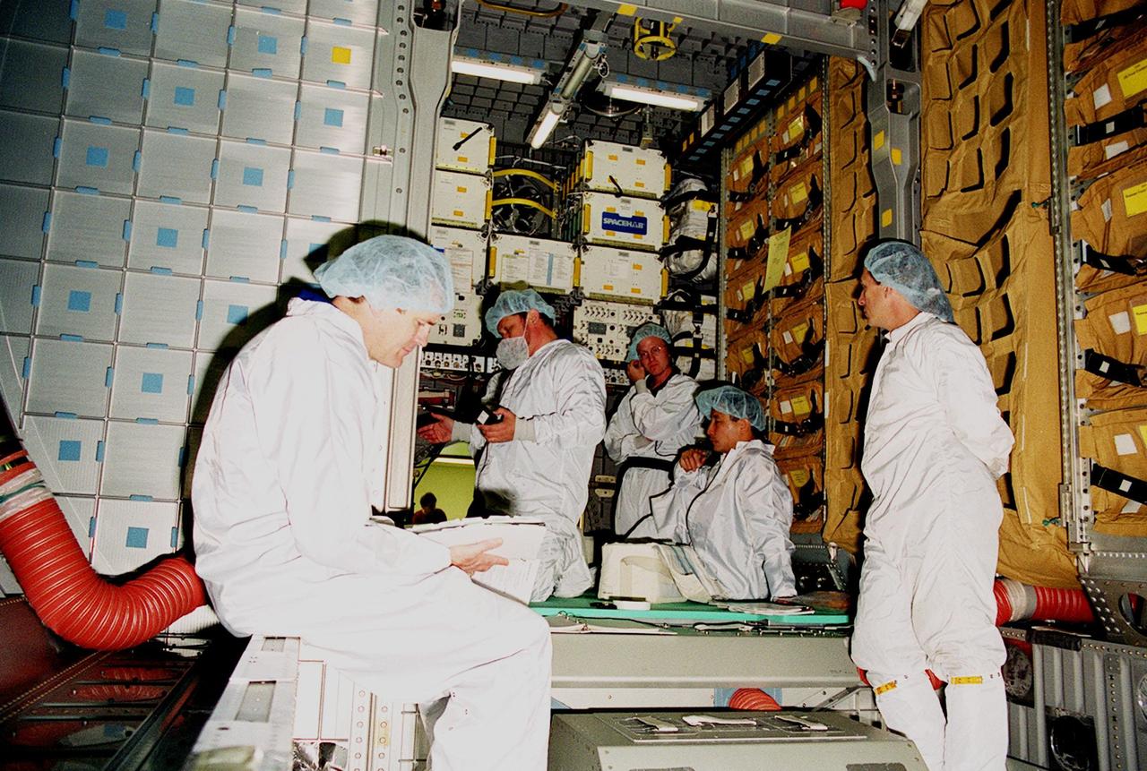 KENNEDY SPACE CENTER, FLA. -- During a Crew Equipment Interface Test (CEIT) at SPACEHAB, in Titusville, Fla., STS-101 crew members check out the SPACEHAB Logistics Double Module that will be part of the payload for their mission. At left are Commander James Donald Halsell Jr. and Pilot Scott J. "Doc" Horowitz (Ph.D.); seated on the floor is Mission Specialist Edward Tsang Lu (Ph.D.). Other crew members who are taking part in the CEIT are Mission Specialists Mary Ellen Weber, (Ph.D.), Jeffrey N. Williams, and Boris W. Morukov and Yuri Malenchenko, who are with the Russian Space Agency. The primary objective of the STS-101 mission is to complete the initial outfitting of the International Space Station, making it fully ready for the first long-term crew. The seven-member crew will transfer almost two tons of equipment and supplies from SPACEHAB. Additionally, they will unpack a shipment of supplies delivered earlier by a Russian Progress space tug and begin outfitting the newly arrived Zvezda Service Module. Three astronauts will perform two space walks to transfer and install parts of the Russian Strela cargo boom that are attached to SPACEHAB's Integrated Cargo Container, connect utility cables between Zarya and Zvezda, and install a magnetometer/pole assembly on the Service Module. Additional activities for the STS-101 astronauts include working with the Space Experiment Module (SEM-06) and the Mission to America's Remarkable Schools (MARS), two educational initiatives. STS-101 is scheduled for launch no earlier than March 16, 2000